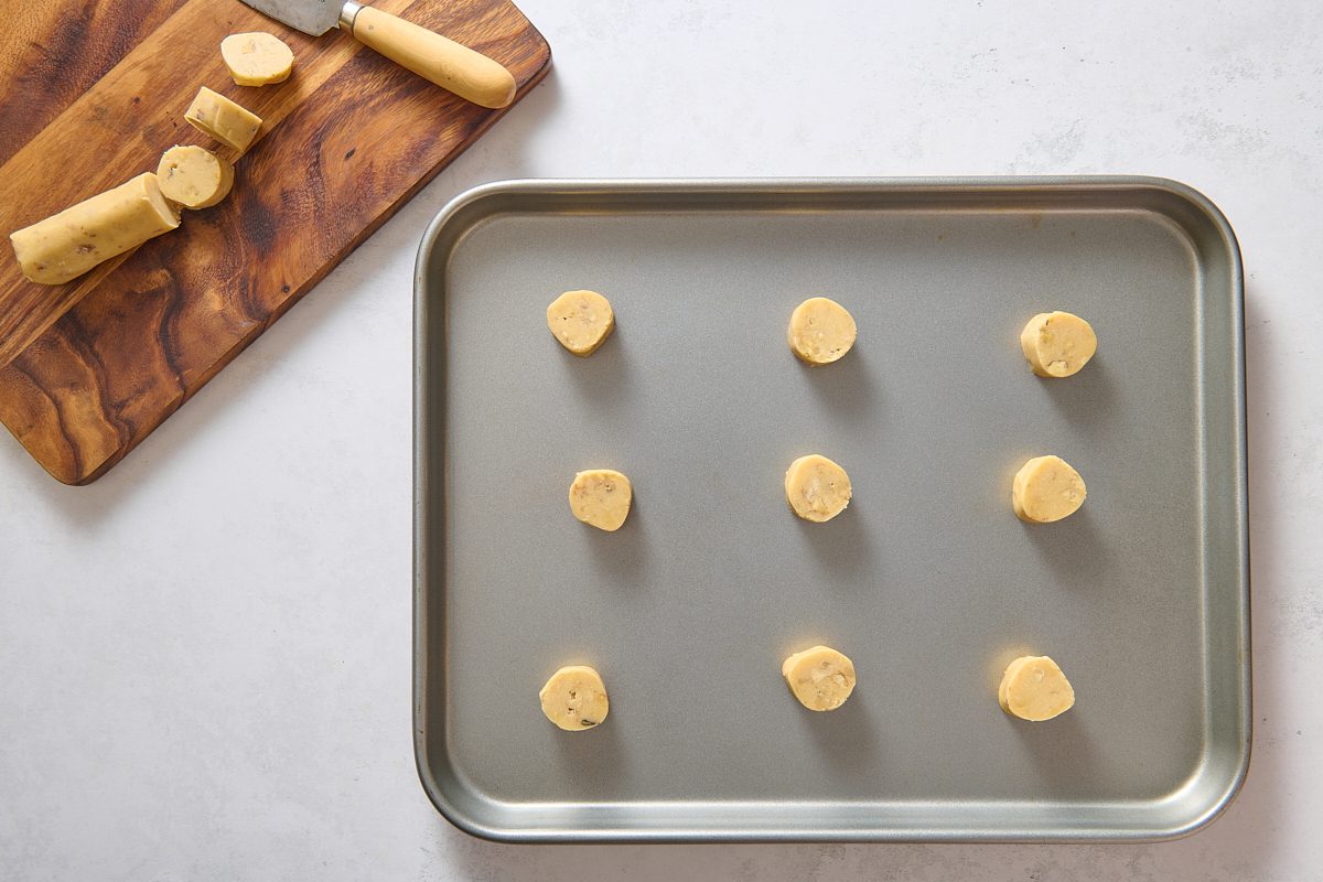 Frozen logs of cookie dough sliced into rounds and placed on a cookie sheet