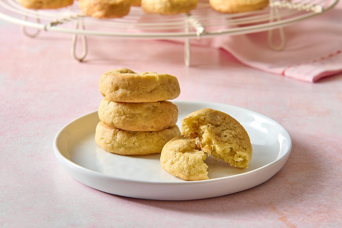 Closeup of icebox cookies stacked on a plate, with one broken in half