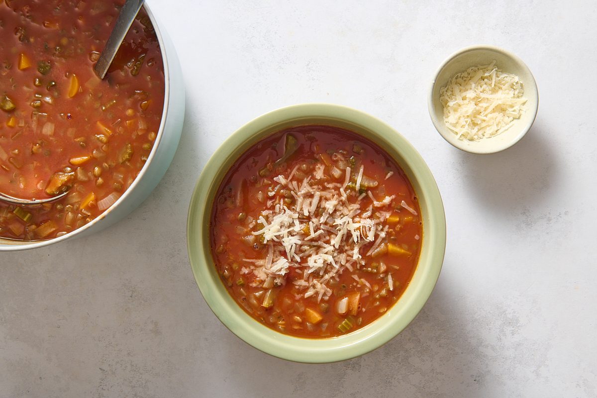 Italian Lentil Soup being served in a bowl and topped with cheese