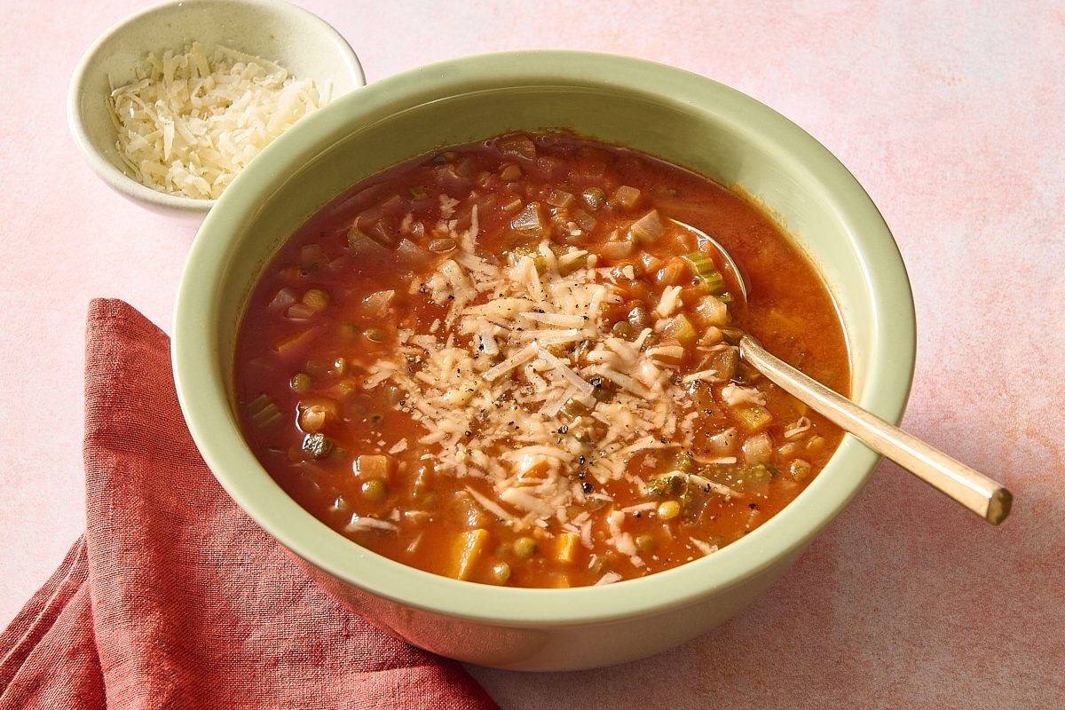 Closeup of Italian lentil soup in a bowl topped with Parmesan cheese