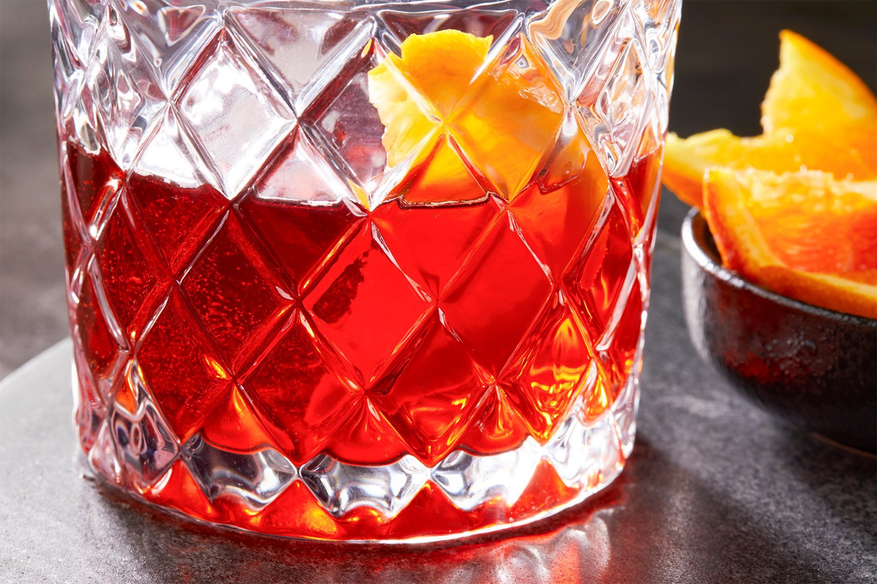 close shot of Negroni Sbagliato garnished with orange slice; rock glass