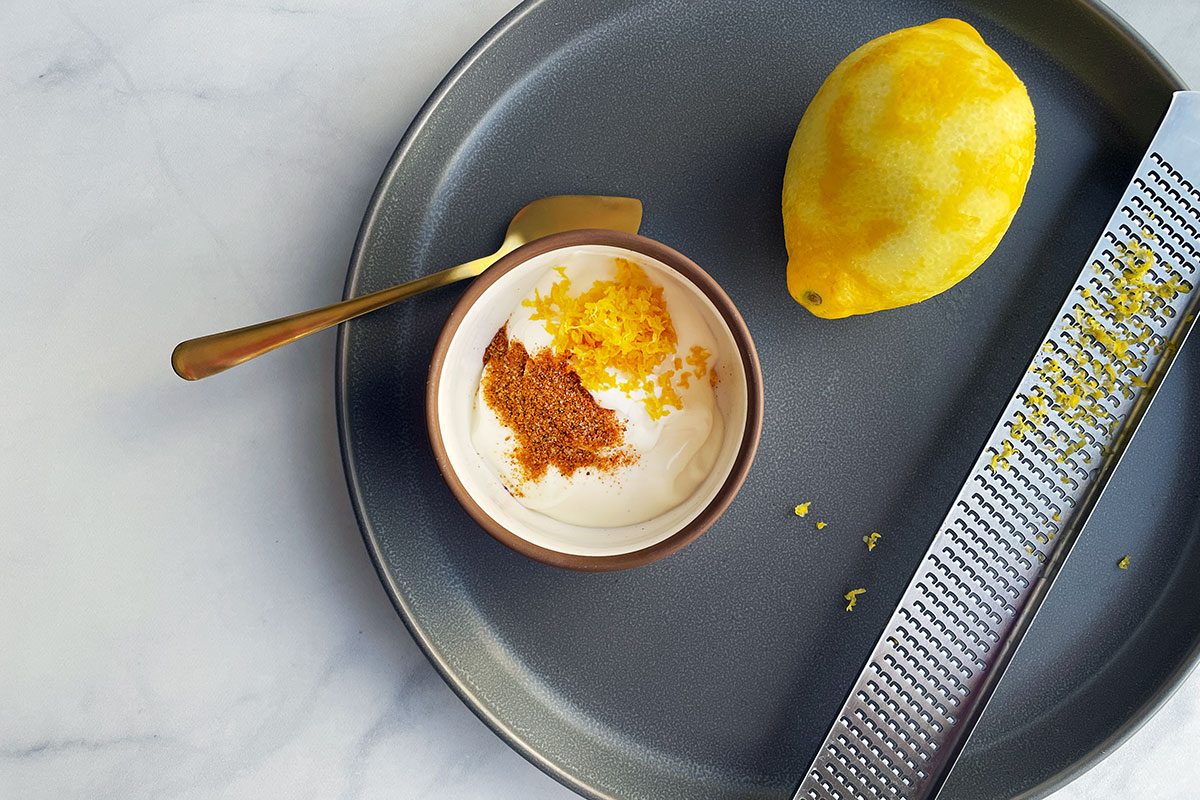 Lemon zested into a bowl with mayonaise and seafood seasoning for shrimp burgers recipe on Taste of Home.