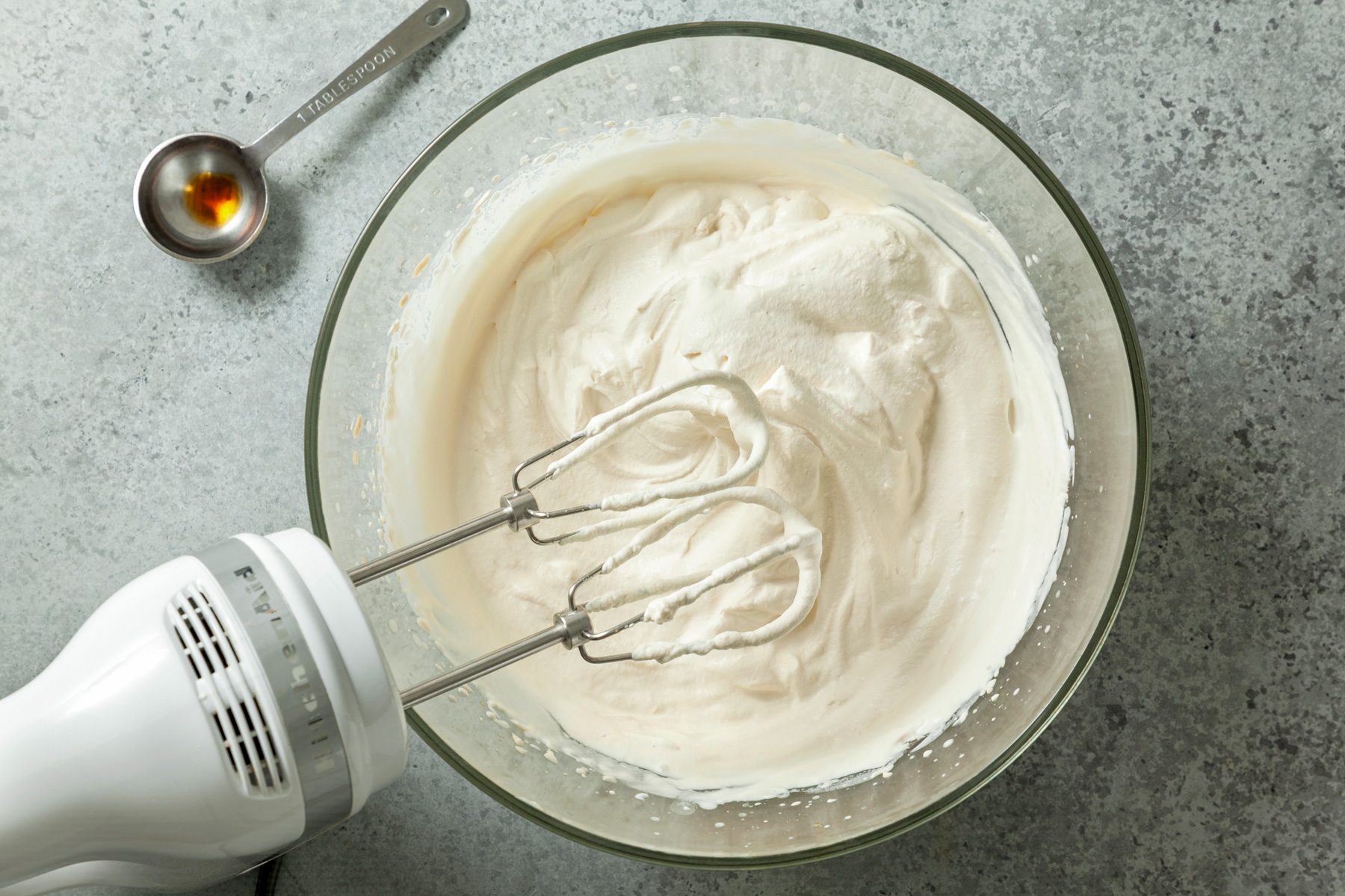 In a large bowl beat the heavy whipping cream and vanilla extract with a hand whisker