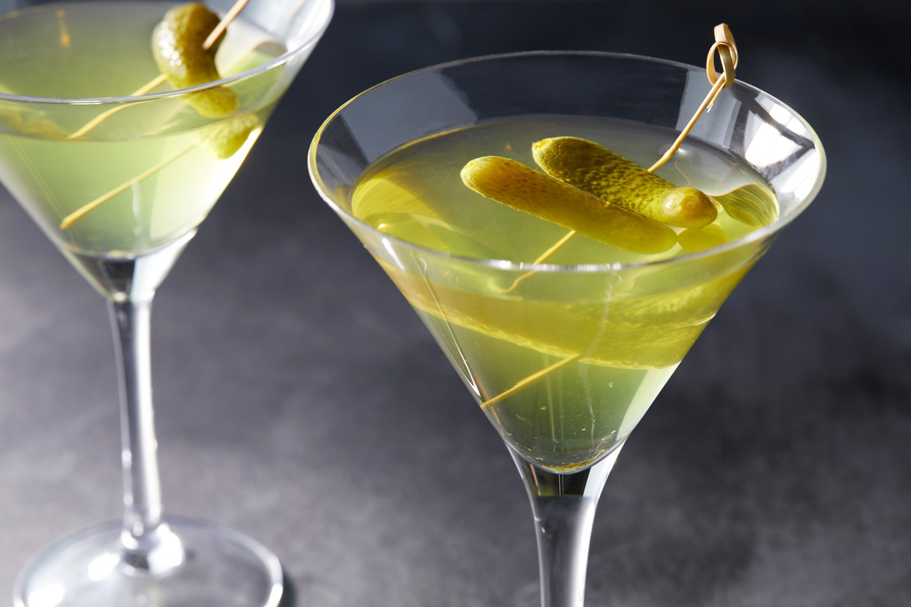 Two glasses of Pickle Martini garnished with a pickle