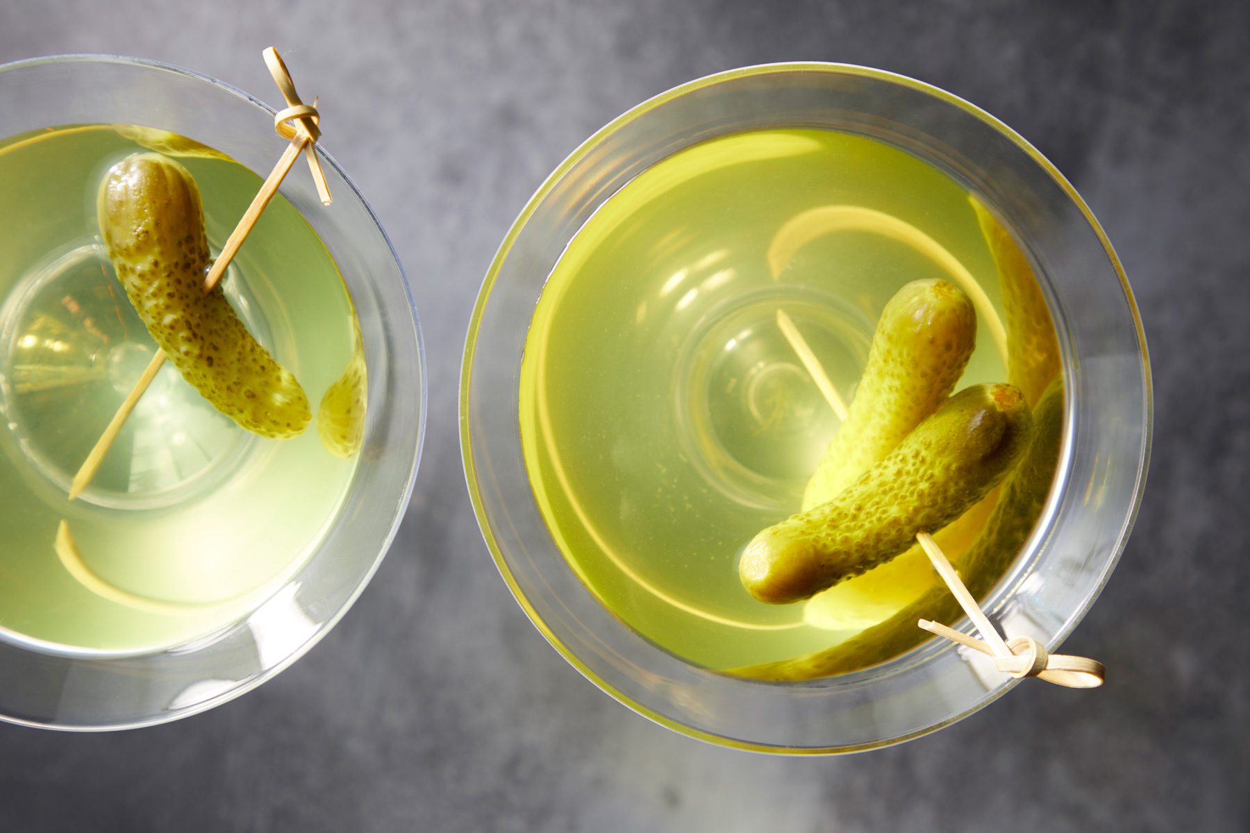 Two glasses of Pickle Martini garnished with a pickle