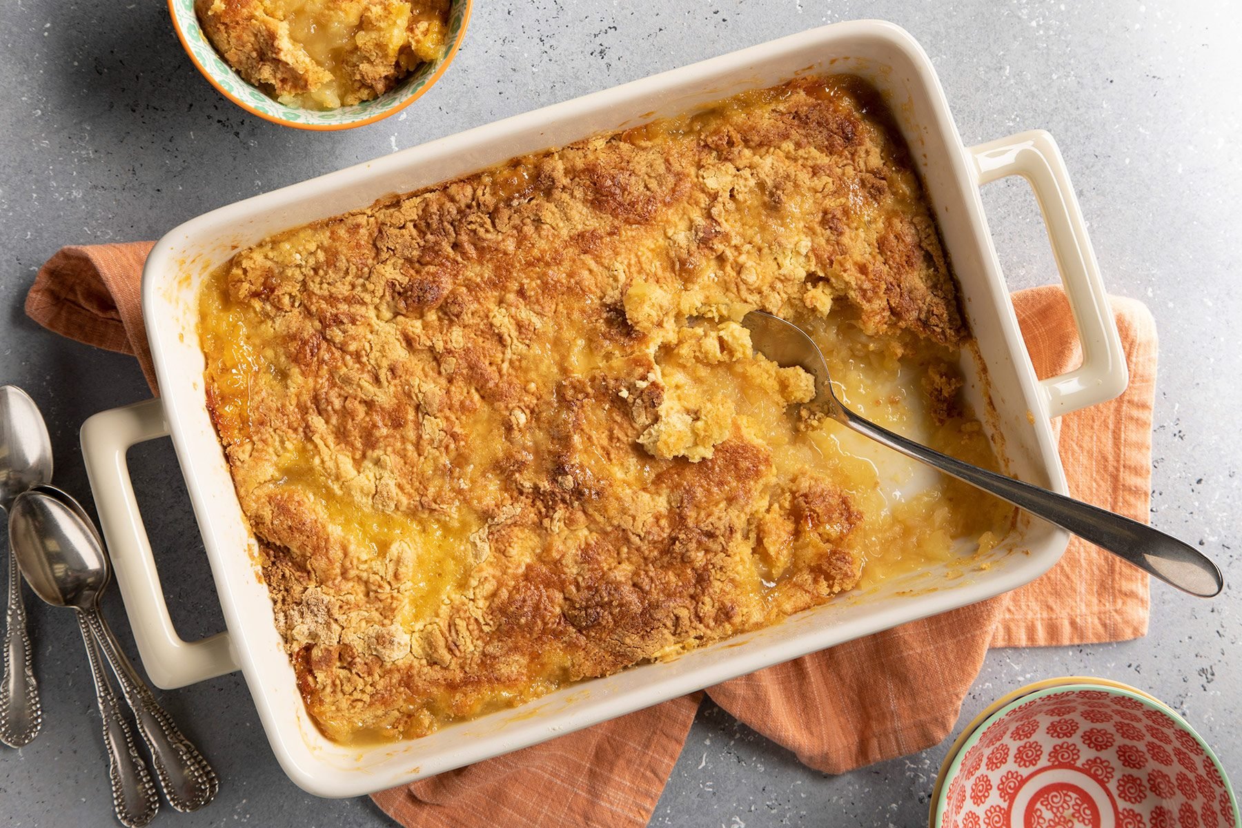 Pineapple Dump Cake in baking dish with spoon