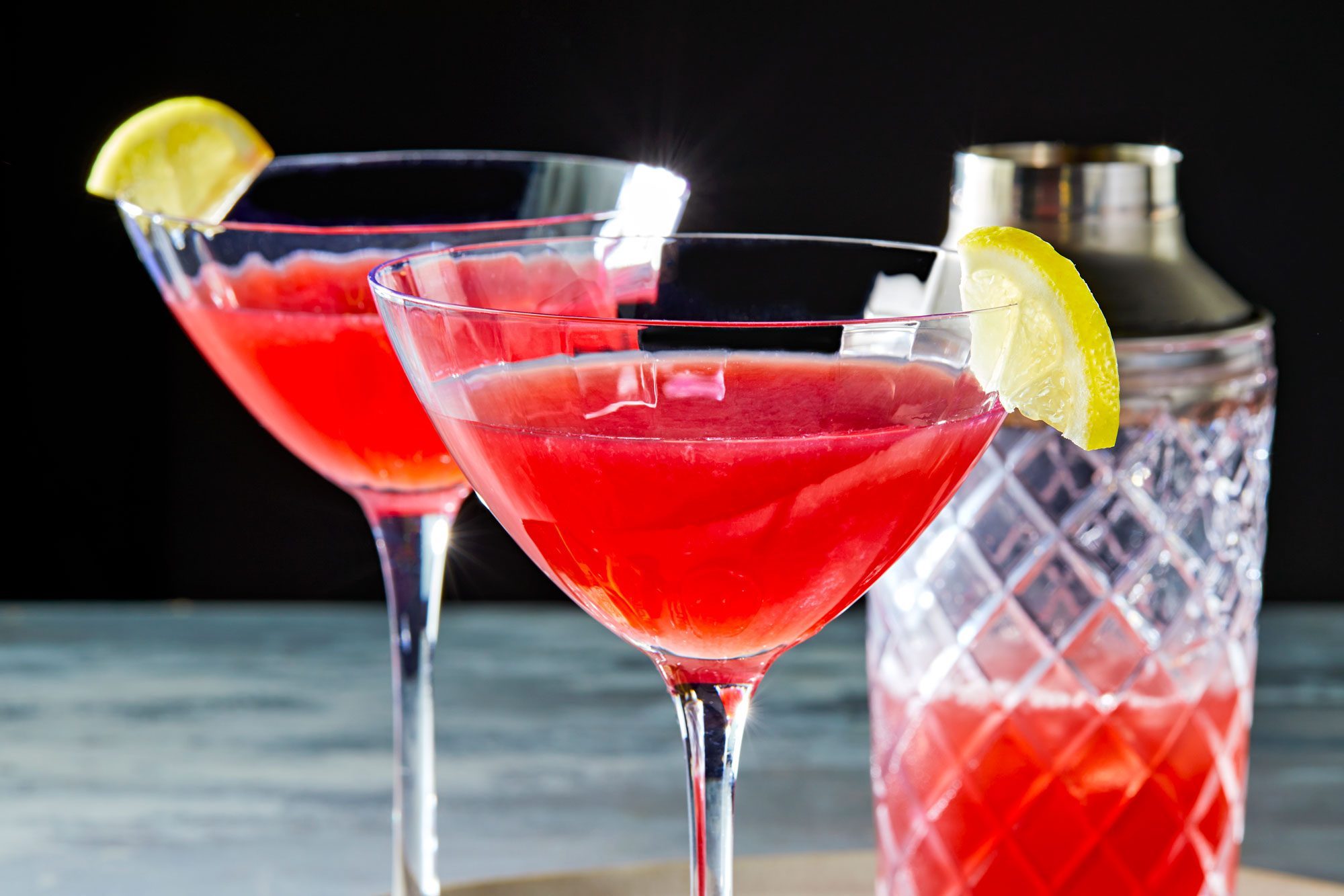 Two glasses of red Pomegranate Martini with a lemon wedge