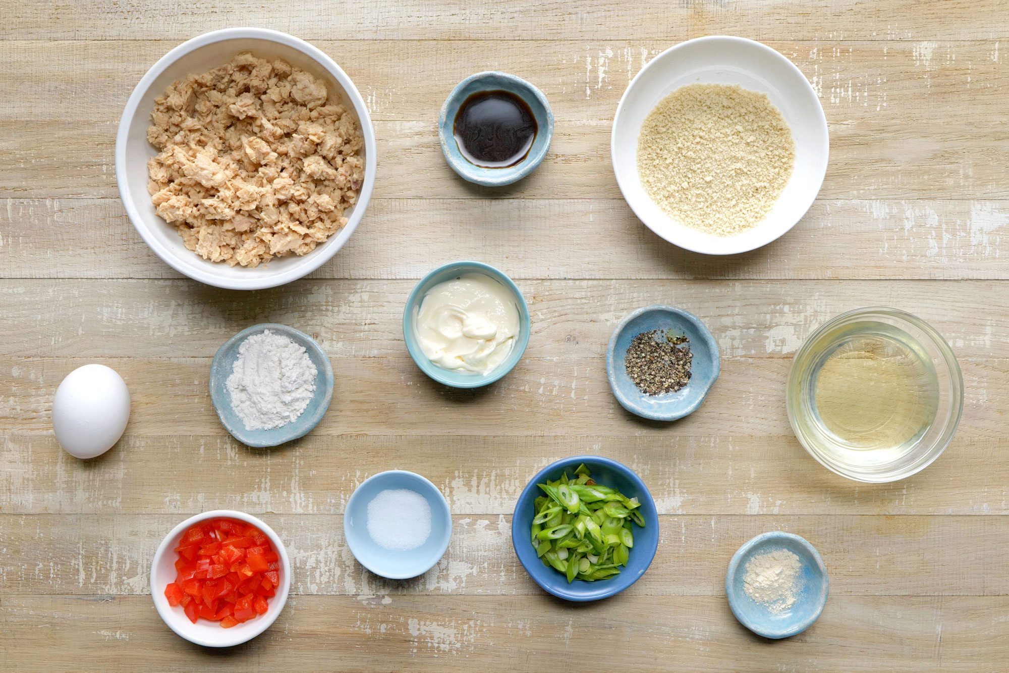 Overhead shot of all ingredients for salmon croquettes; wooden background;