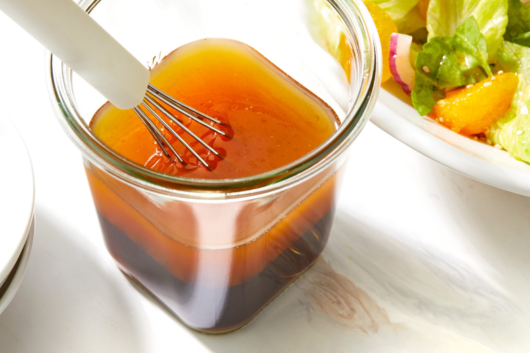 A jar of Sesame Salad Dressing with Whisk