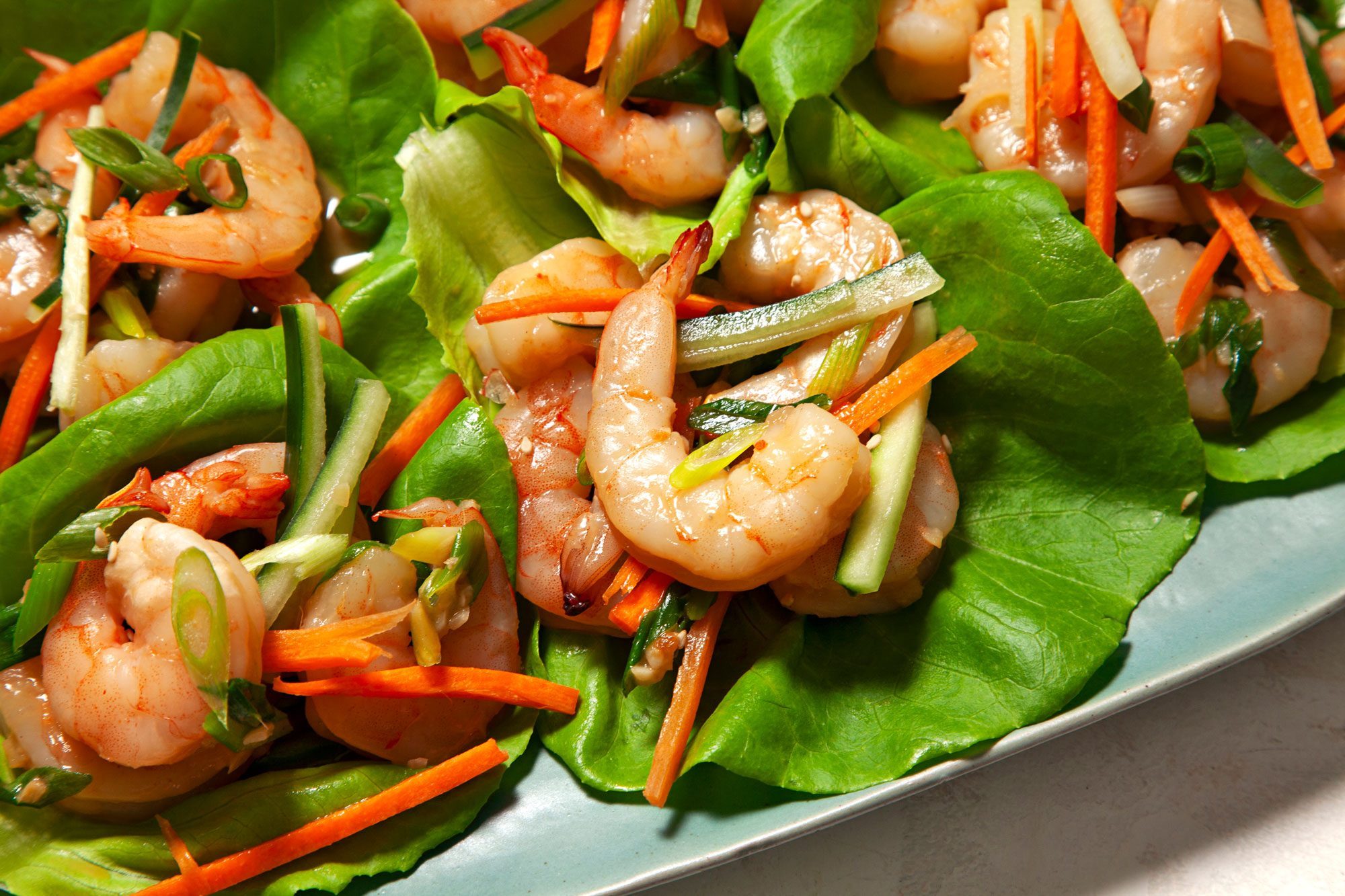 Shrimp Lettuce Wraps served and topped with the chopped carrots and cucumber