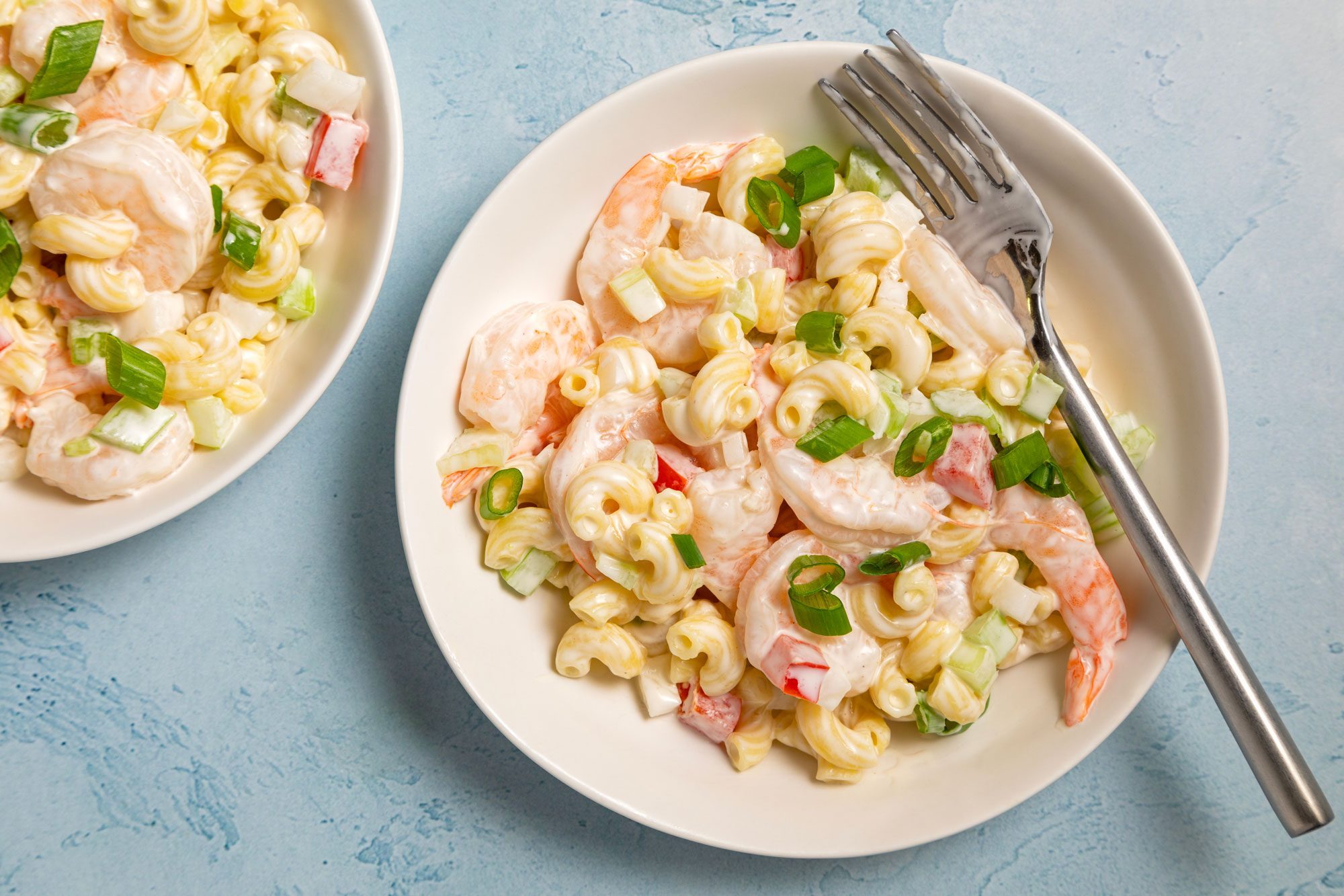 Two plates of Tasty Shrimp Pasta Salad served on small plates with cutlery