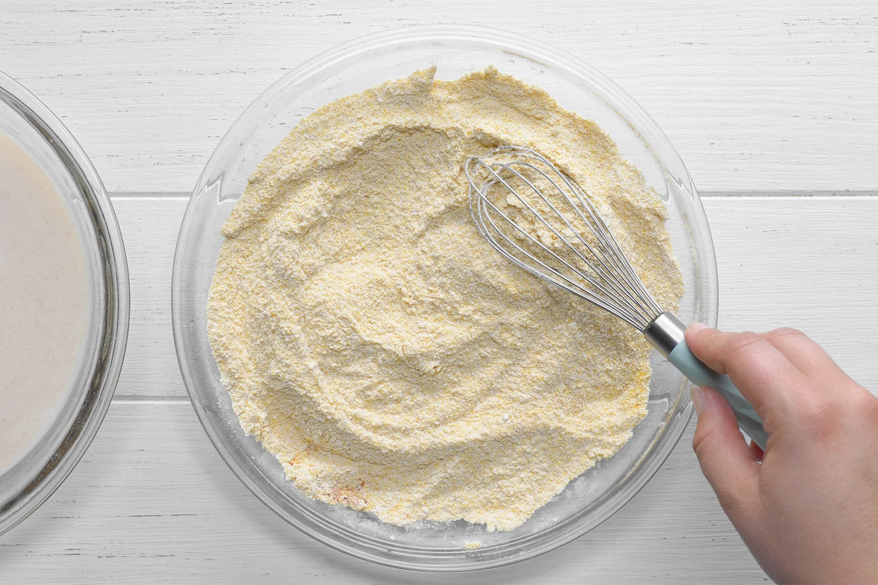 overhead shot; white background; In a separate shallow bowl combining flour, cornmeal, salt, paprika, garlic powder and cayenne