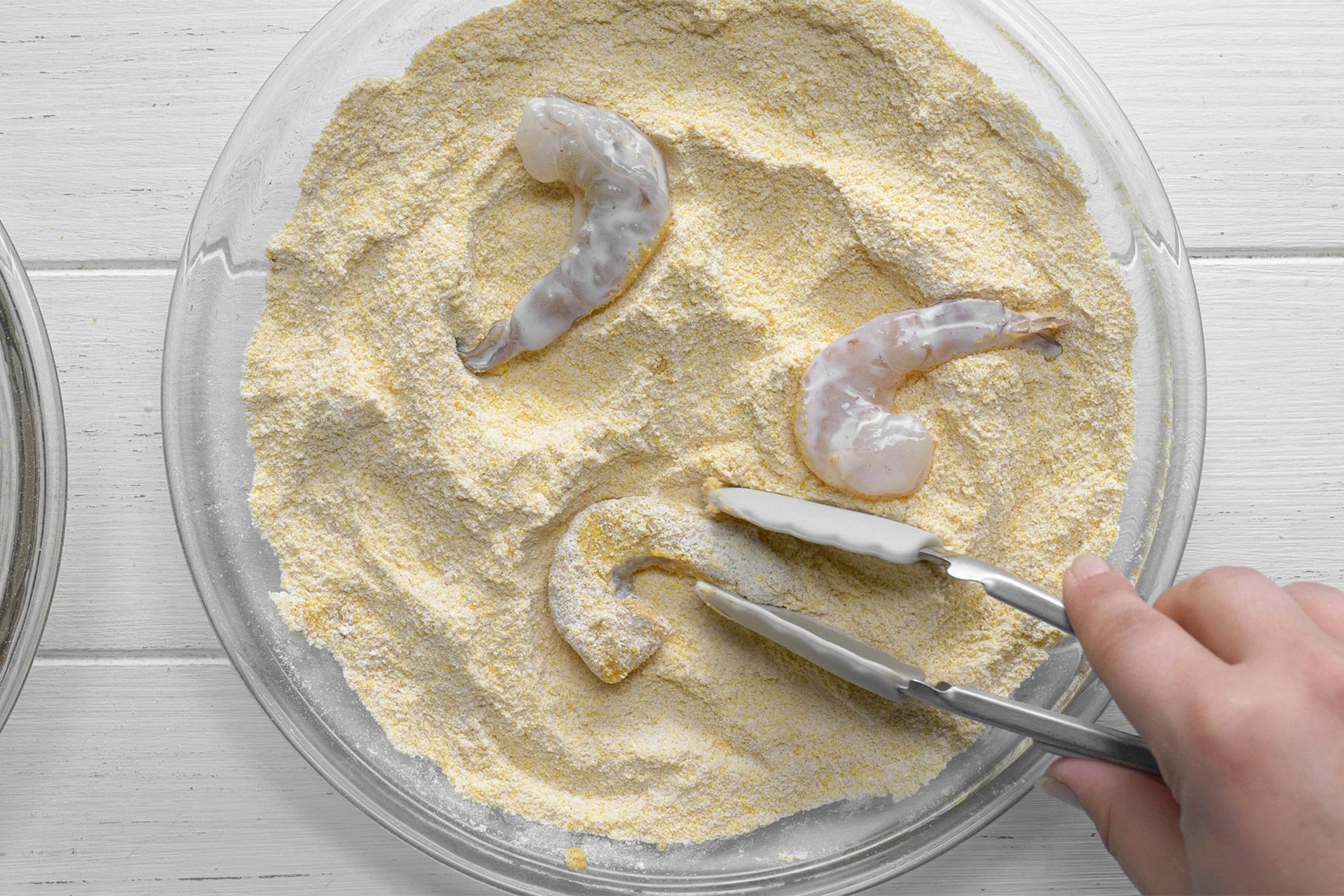 overhead shot; white background; coating shrimps with flour mixture