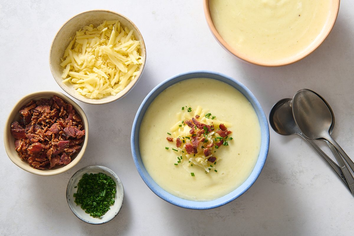 Ladling soup into bowls and adding toppings