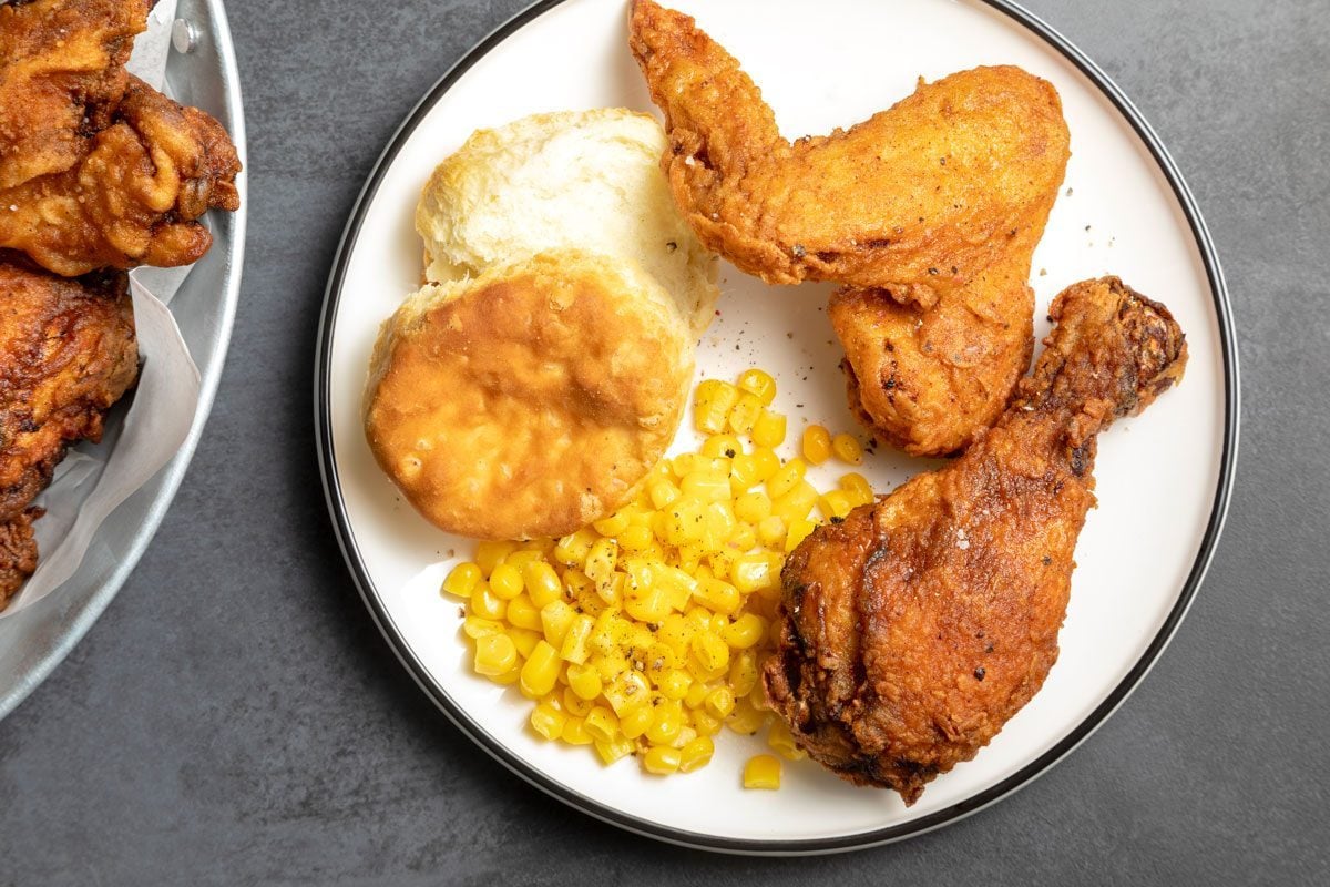 Spicy Fried Chicken on a plate with biscuit and corn