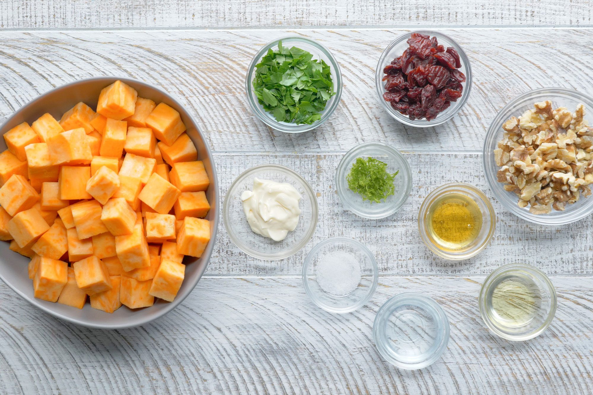 overhead shot of all ingredients for Sweet Potato Salad; white wooden background;