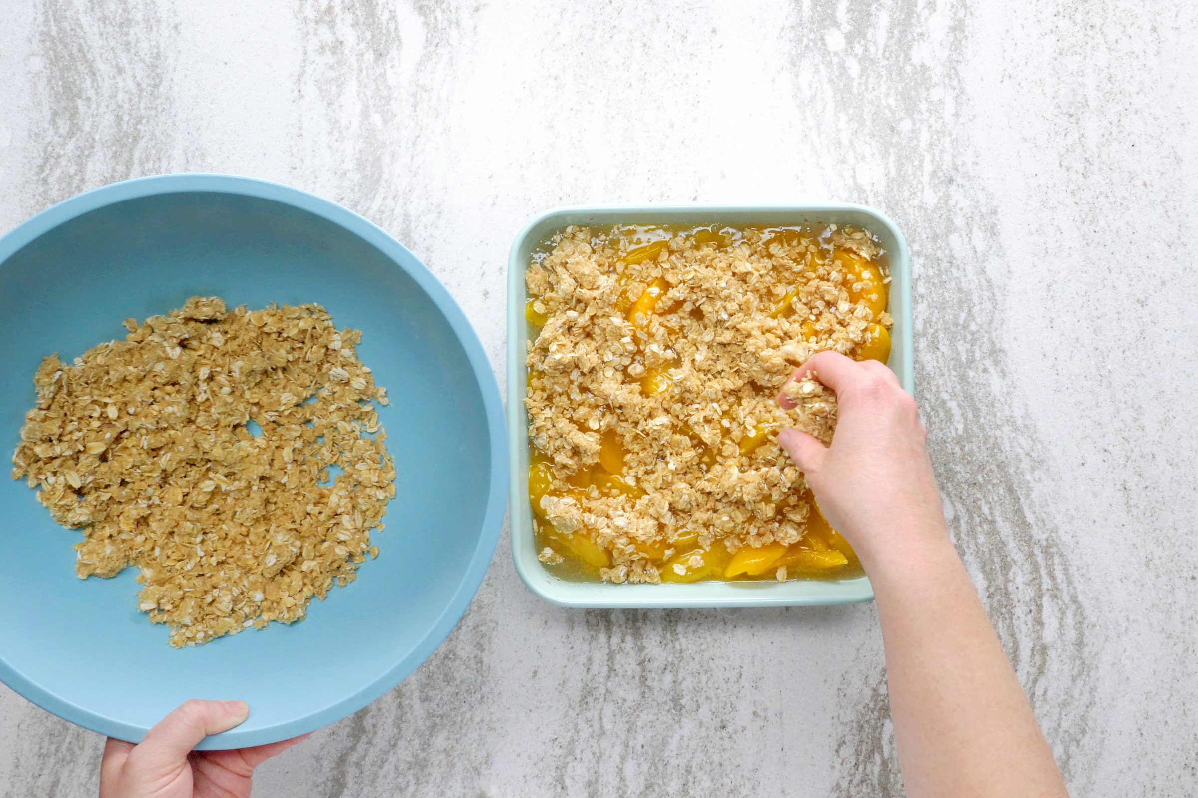 putting crumble on peach crisp in a baking pan before baking