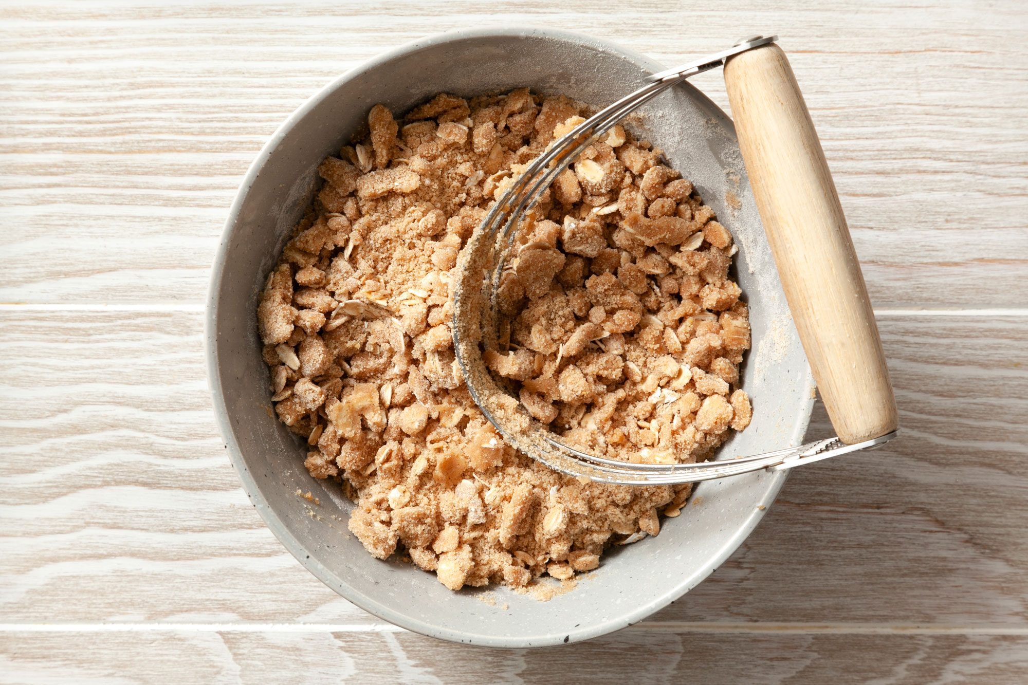 overhead shot; wooden background; In a small bowl, combine brown sugar, flour, oats, and other ingredients;