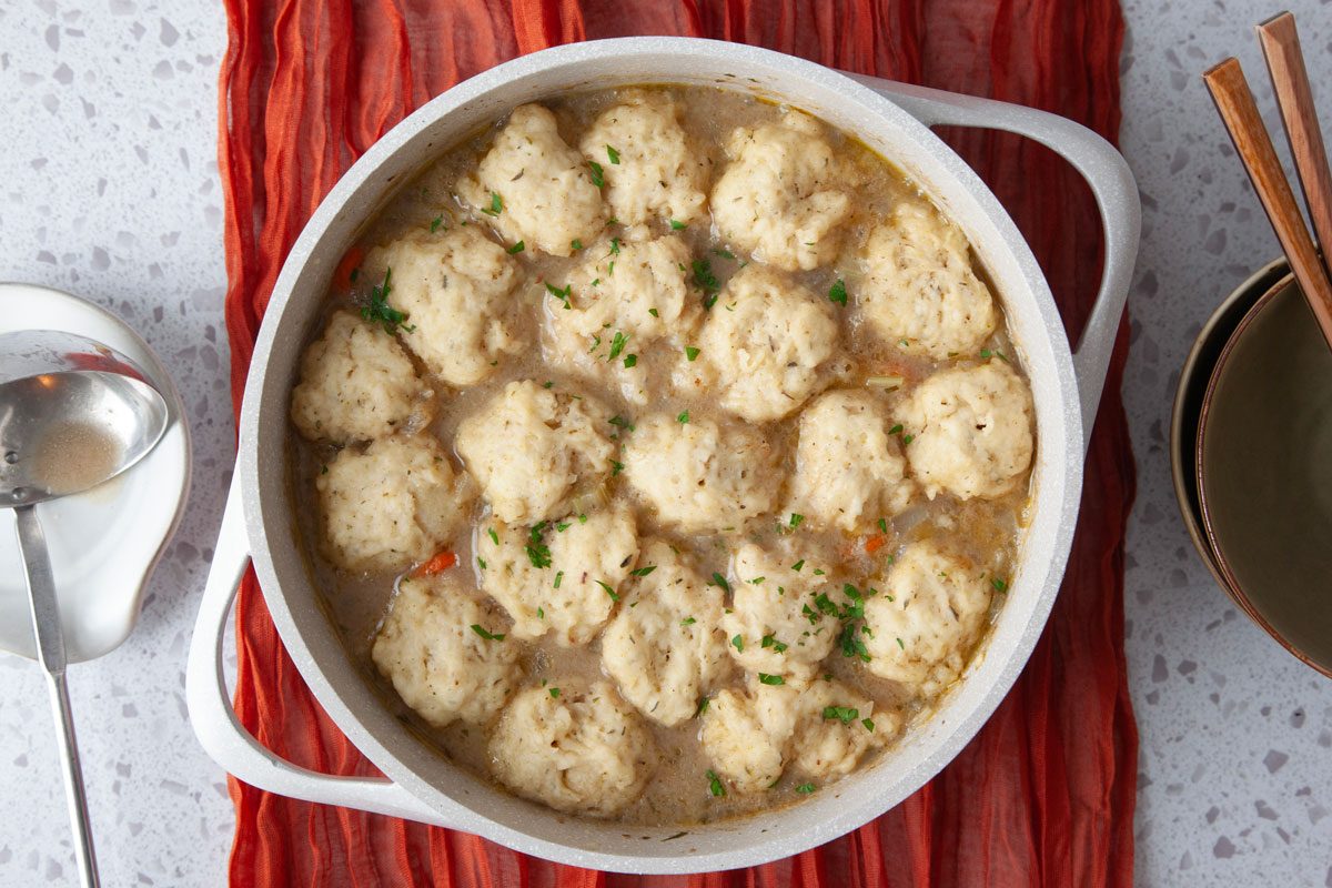 Full yield of Taste of Home Beef Stew with Dumplings in a large Dutch oven, red table runner