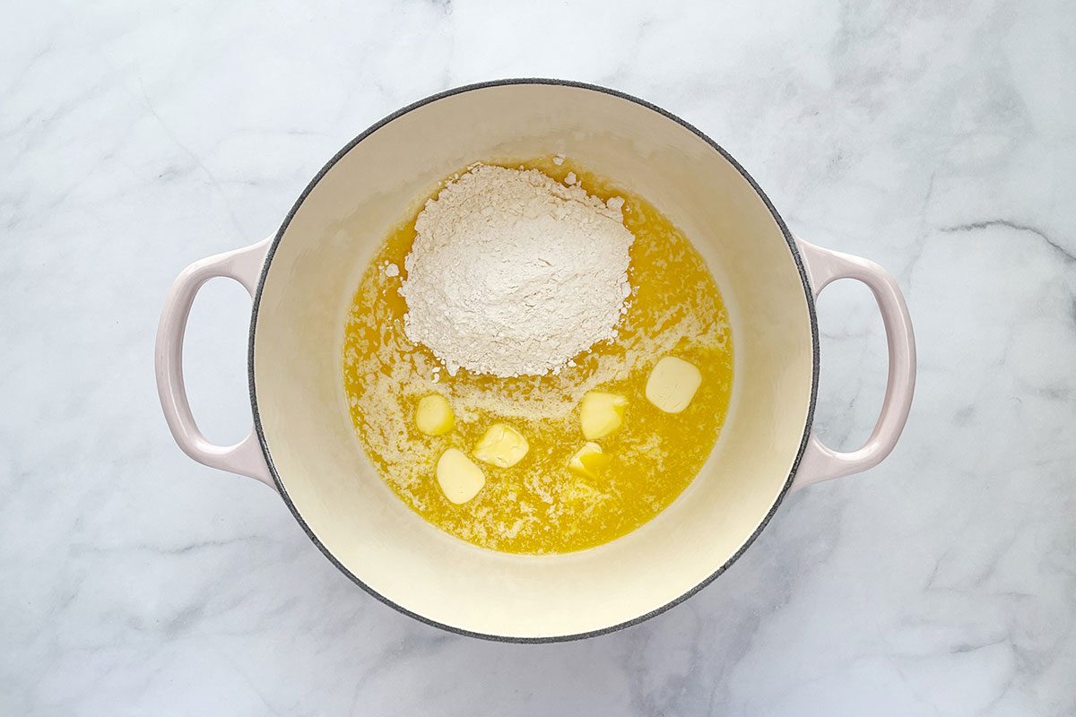 Step 1 for how to make Taste of Home's Beer Cheese Soup recipe; whisking flour and butter into a roux in a dutch oven