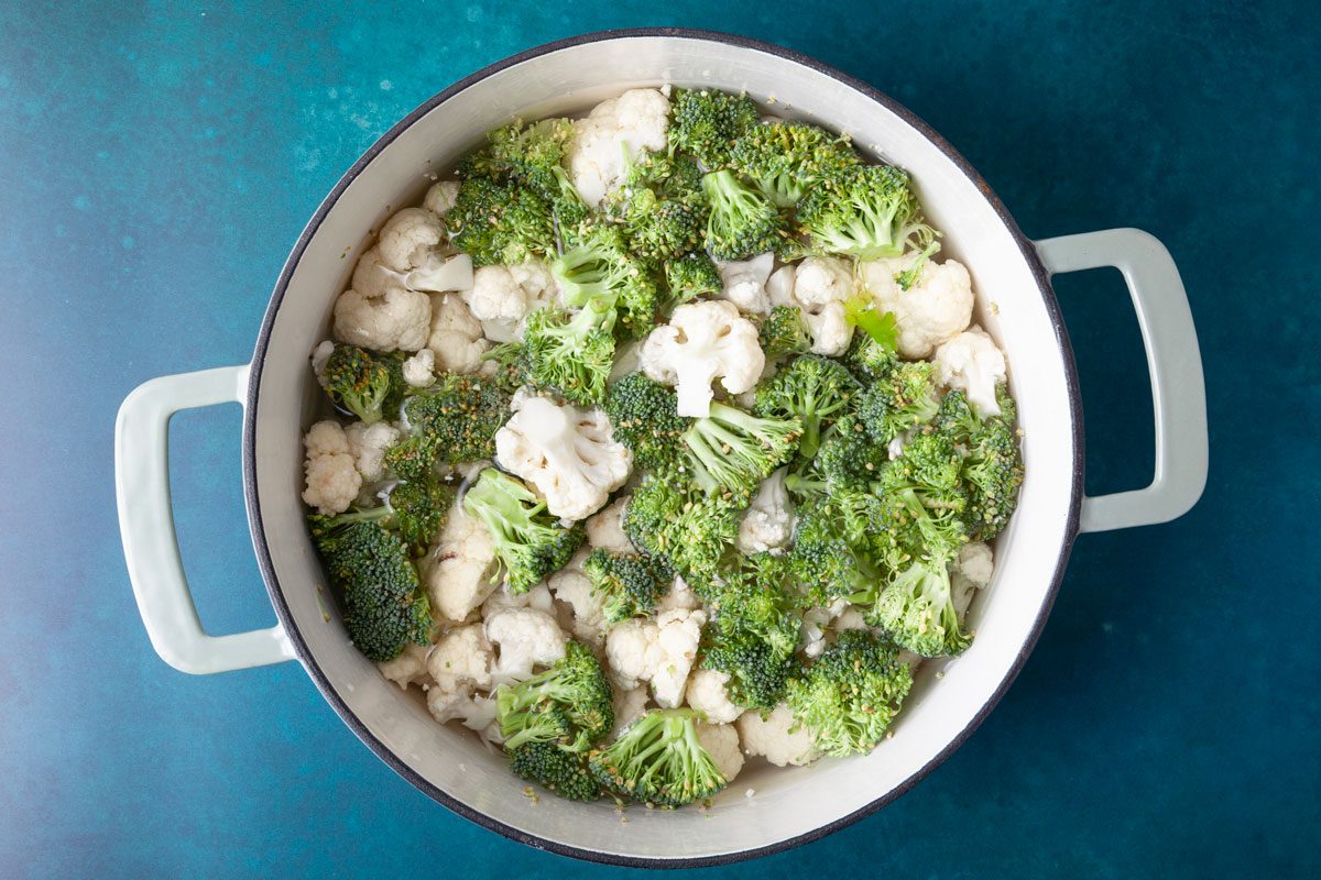 Step 1 of Taste of Home Broccoli Cauliflower Bake is to boil the vegetables in water until tender