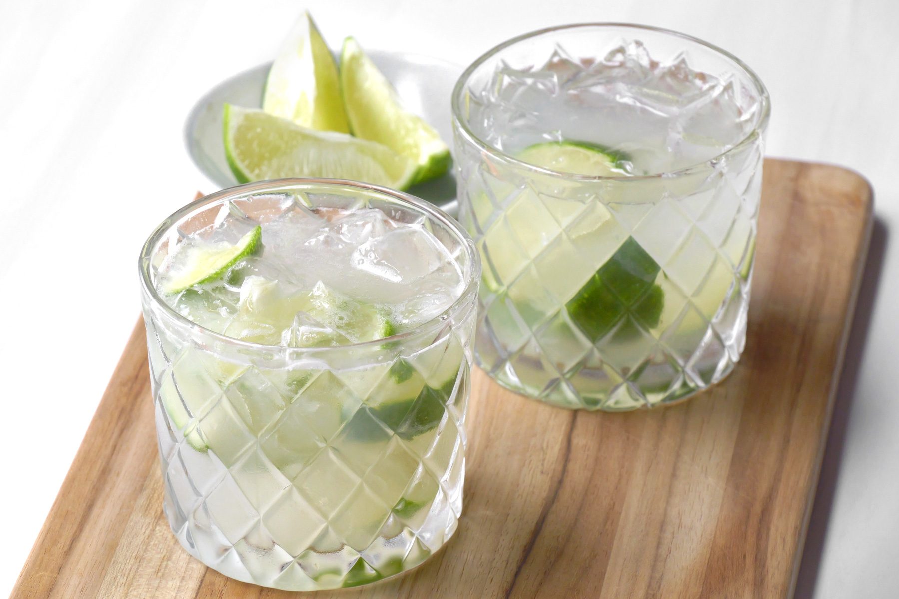 Two glasses of Caipirinha drinks with lemon slices