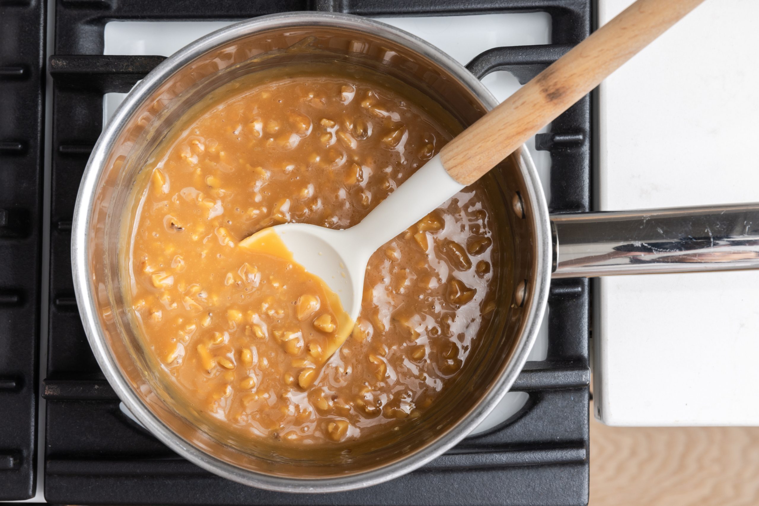 Caramel sauce being prepared in sauce pan.