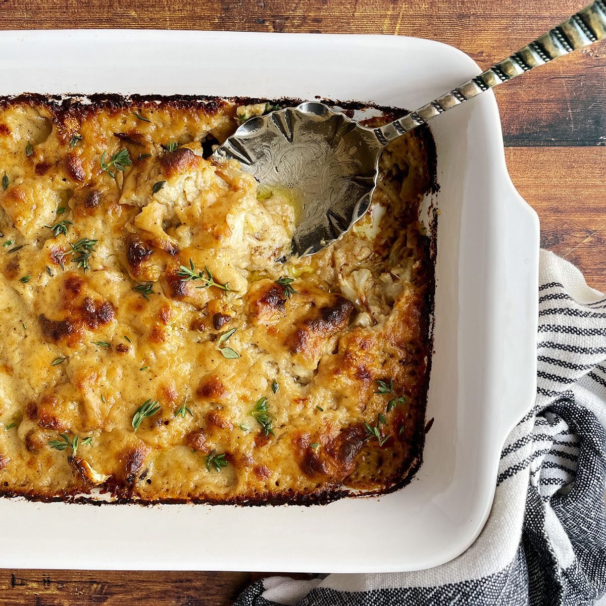 Overhead shot of Taste of Home's Cauliflower Gratin in a baking dish on a dark wood background