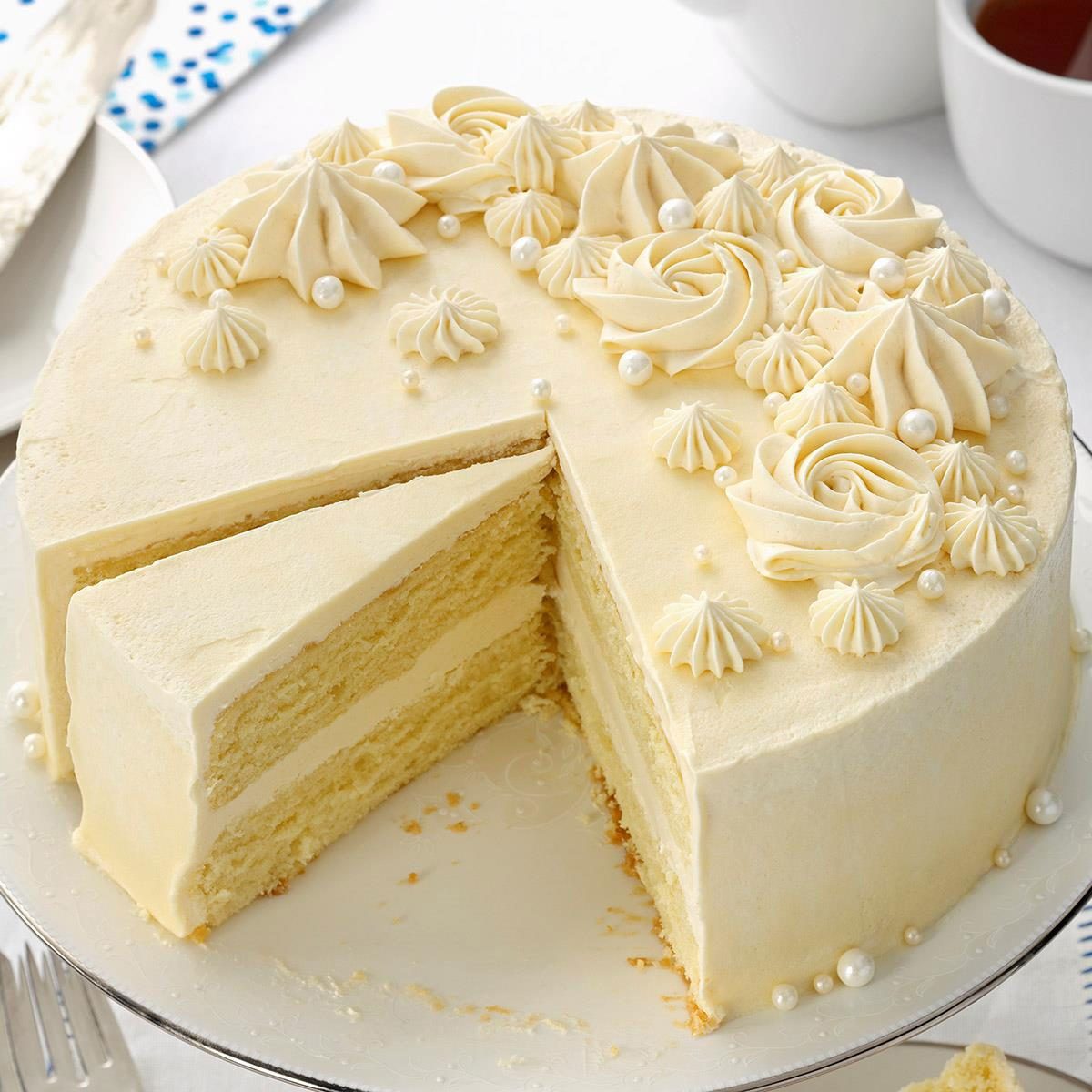 Eggnog Cake on a cake stand with a slice taken out to show the texture and laters