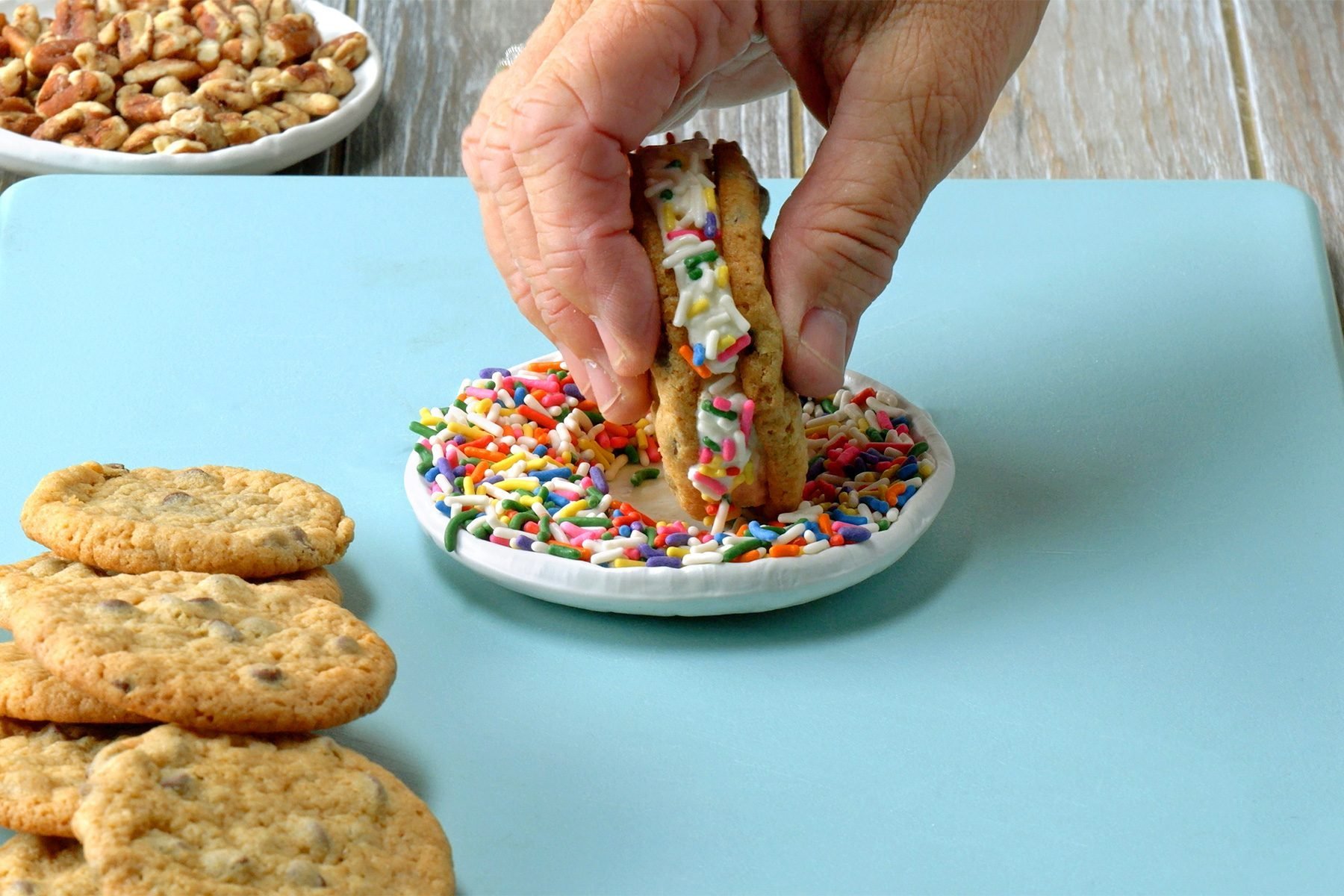 Roll sides of ice cream sandwich in chocolate chips, pecans and/or sprinkles.