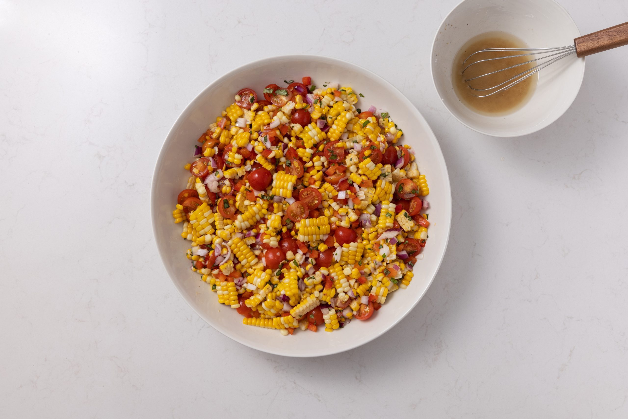 Salad ingredients and dressing mixed in large serving bowl.