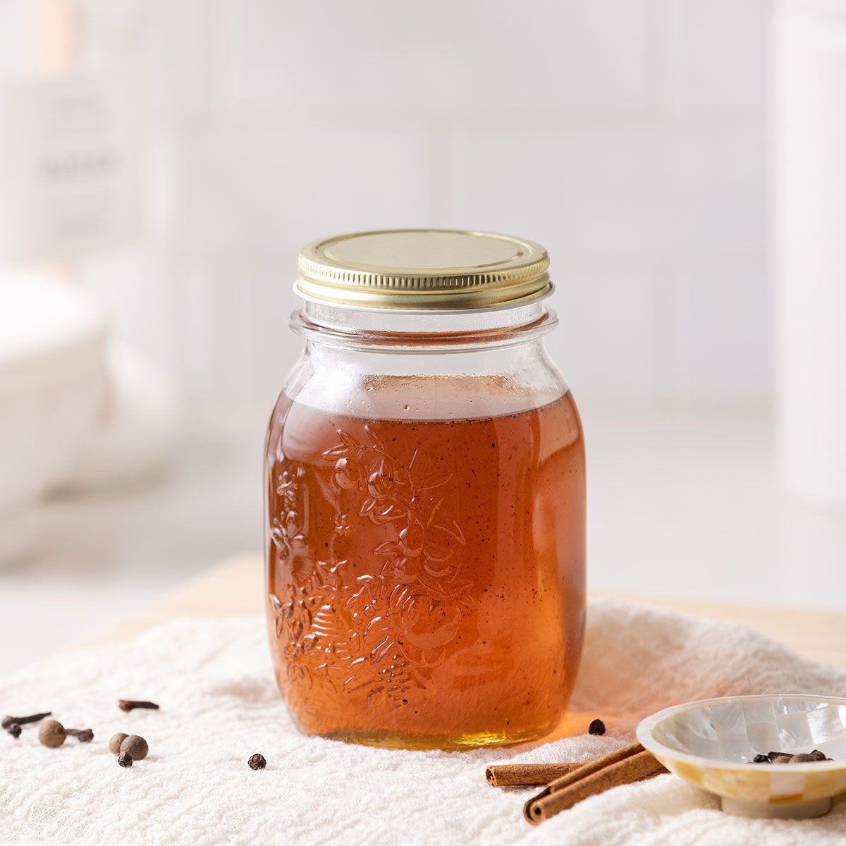 Gingerbread syrup in air tight container with spices on the side.