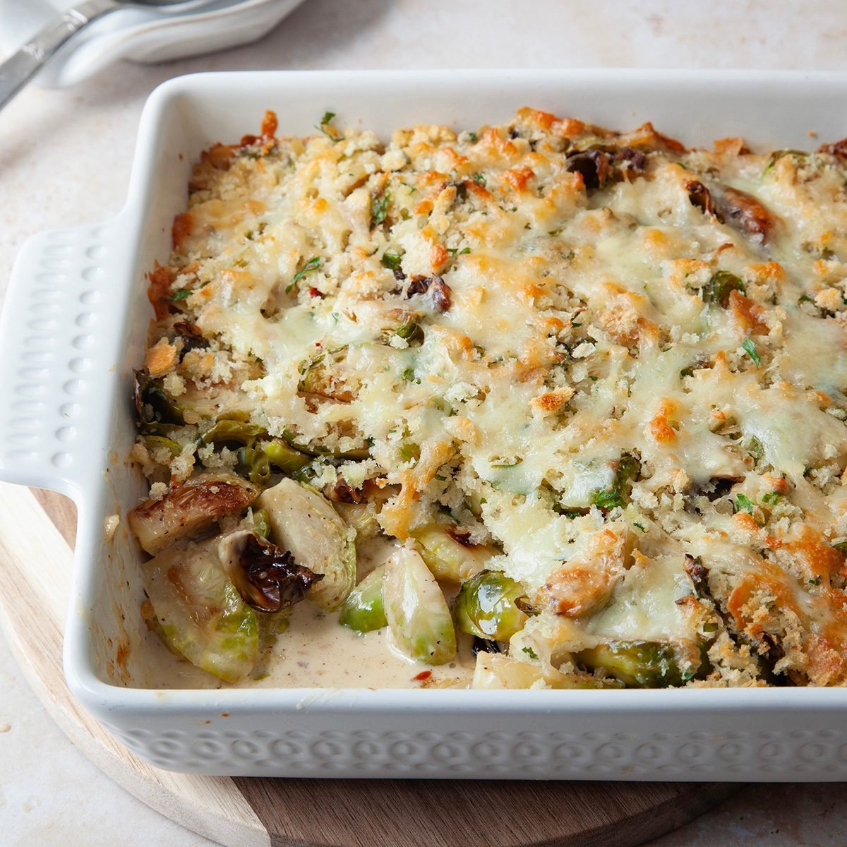 Taste Of Home Brussels Sprouts Au Gratin In An 8x8 Baking Dish On Wooden Trivet