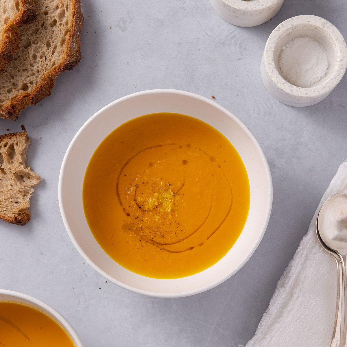 Bowl of carrot ginger soup served with side of bread