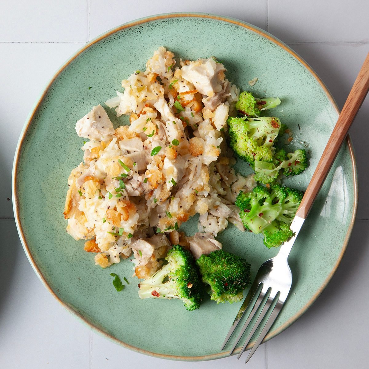 single serving of Taste of Home Poppy Seed Chicken on a green plate with broccoli