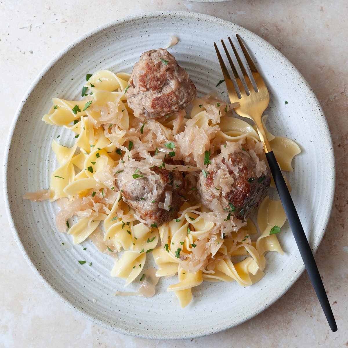 Single servings of Taste of Home German Meatballs over egg noodles garnished with parsley