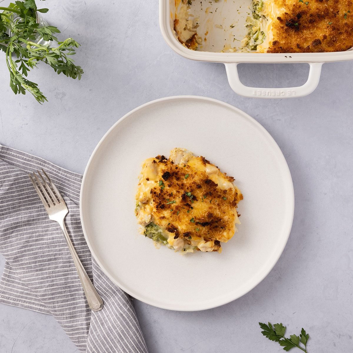 Casserole served on plate with baking dish close by.