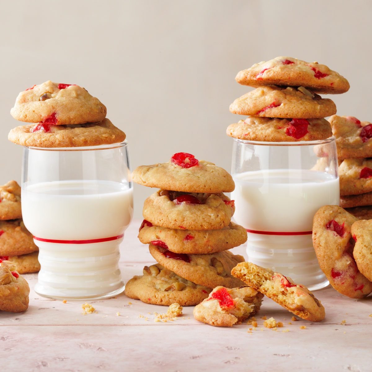 Cherry Cookies served with a glass of milk on a pink tile background