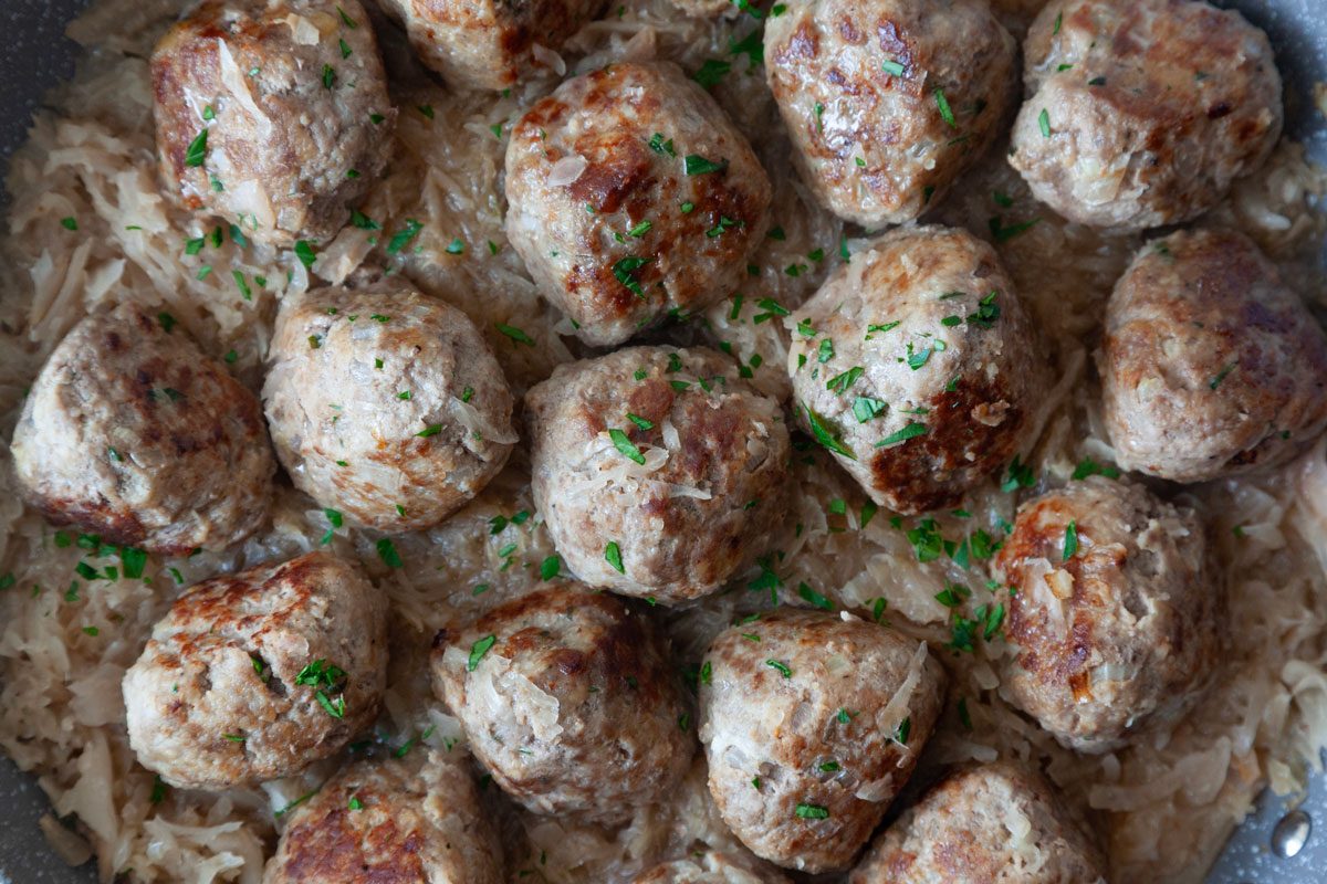 Close up of Taste of Home German Meatballs in a dark gray pan garnished with parsley