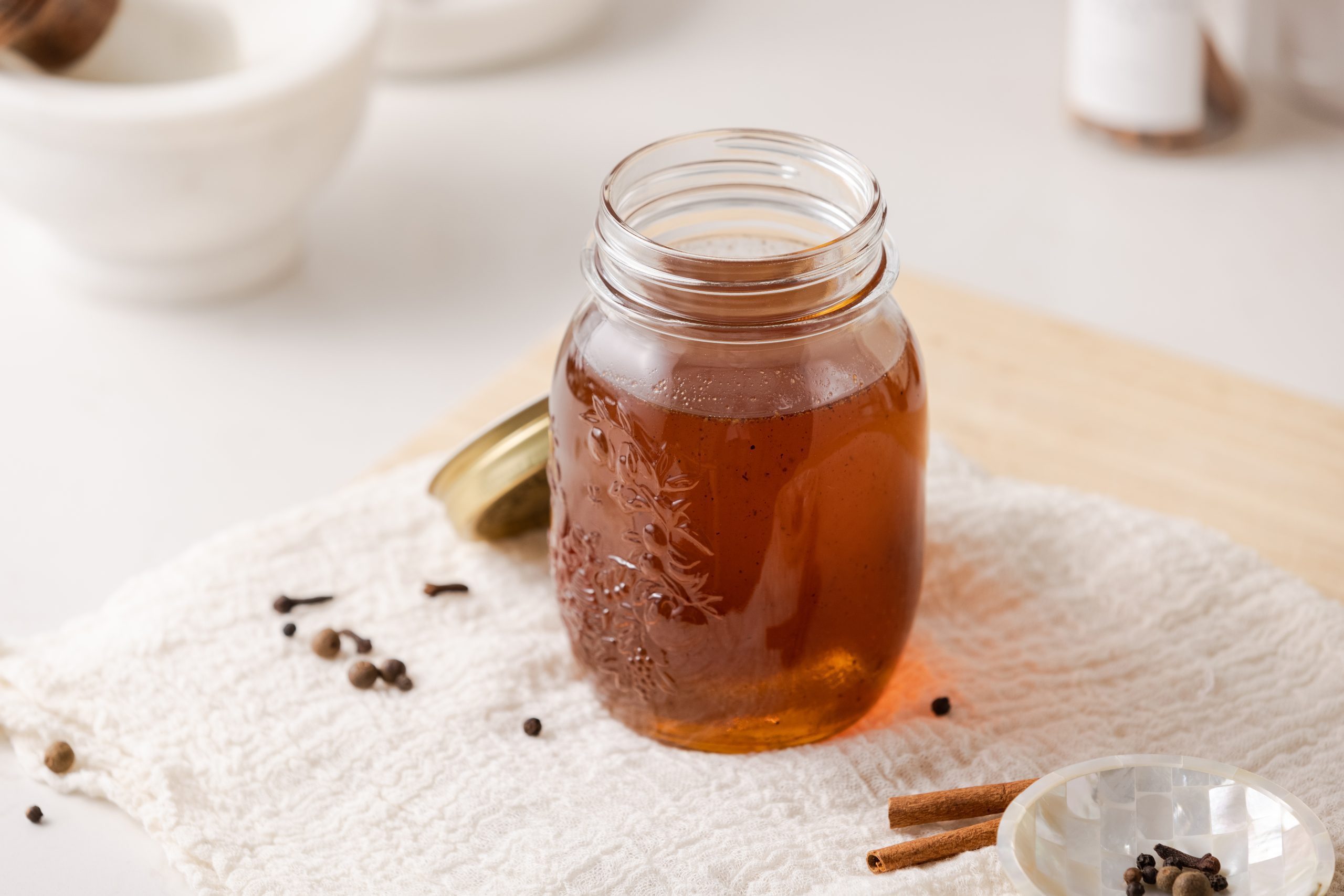 Gingerbread syrup in container with spices on the side.