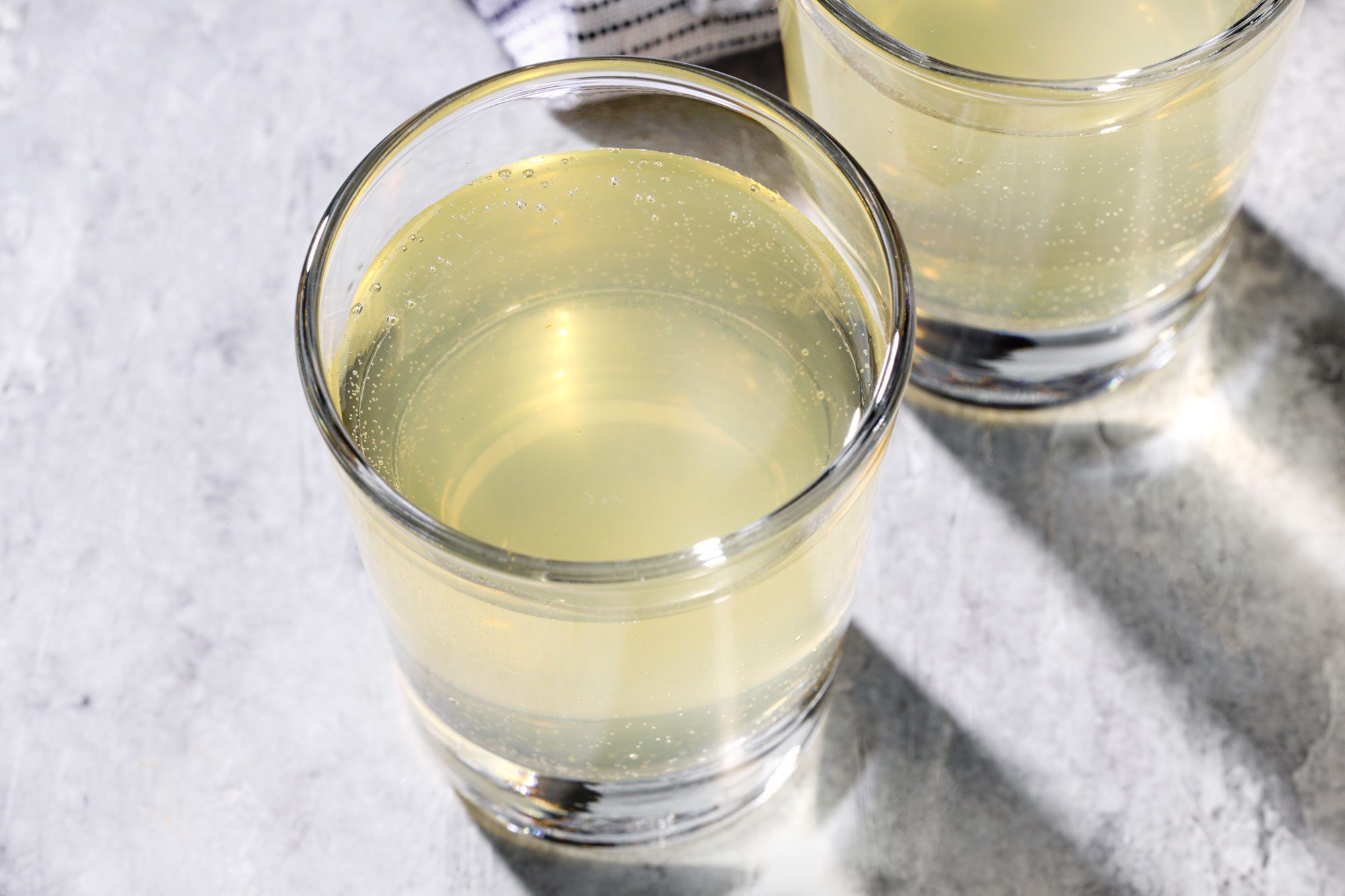Top view shot of Green Tea Shots; served in glasses; napkin; marble background;