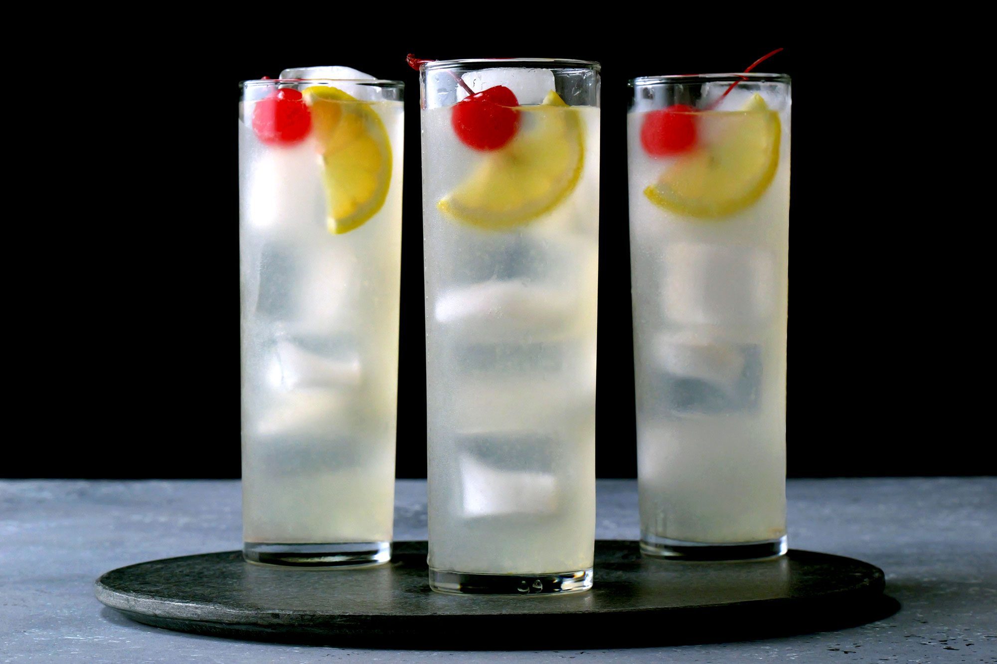 Lemon Tom Collins garnished with lemon slice and cherry