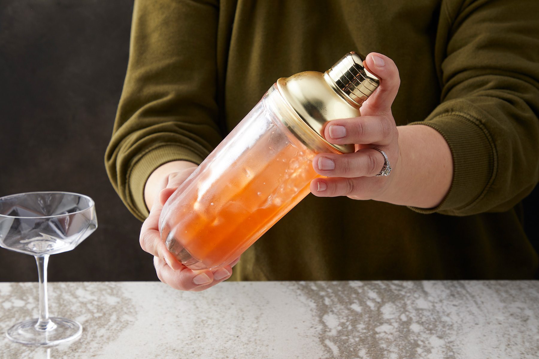 wide shot of shaker filled with paper plane drink; coupe glass;