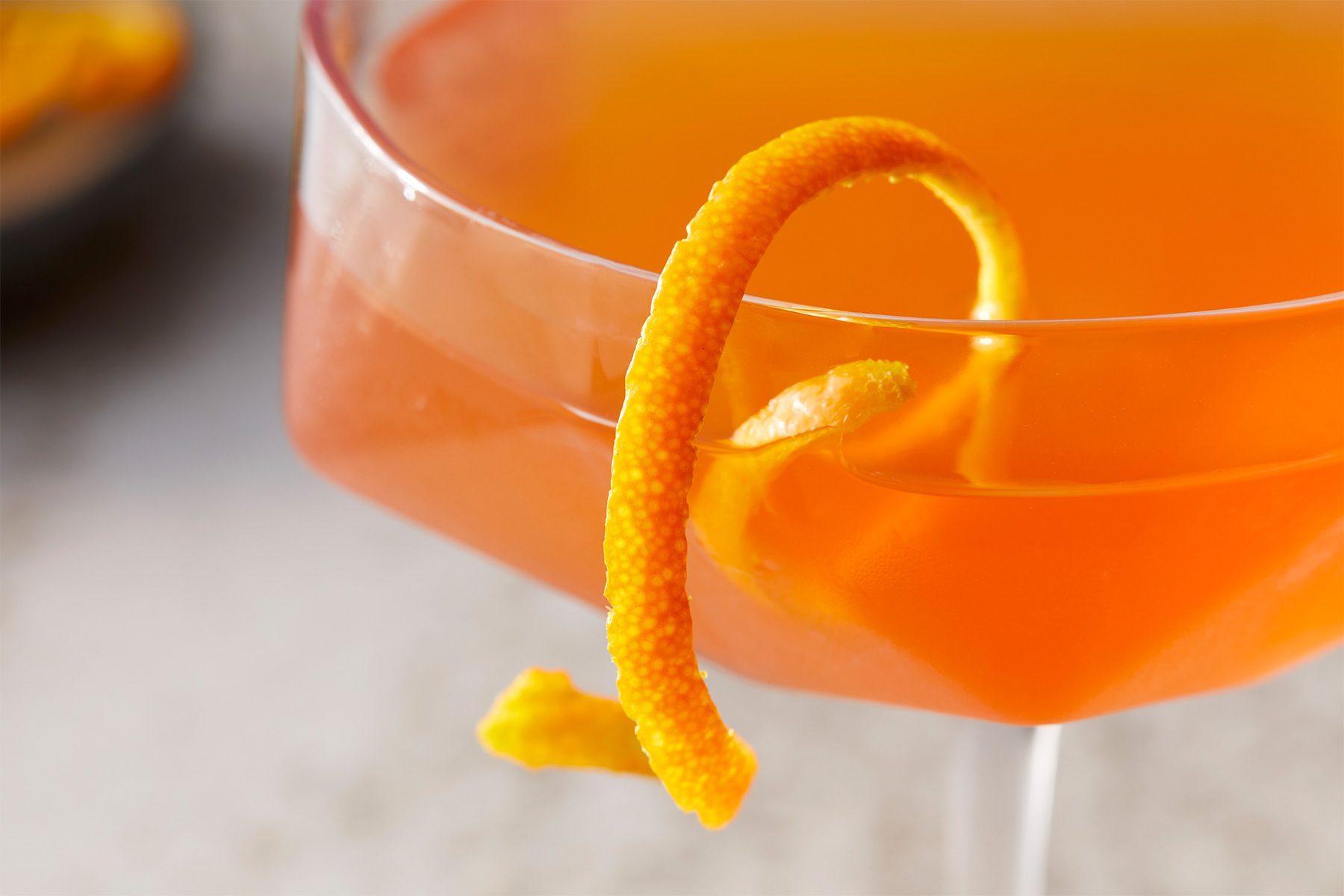 close shot of paper plane garnished with orange peel