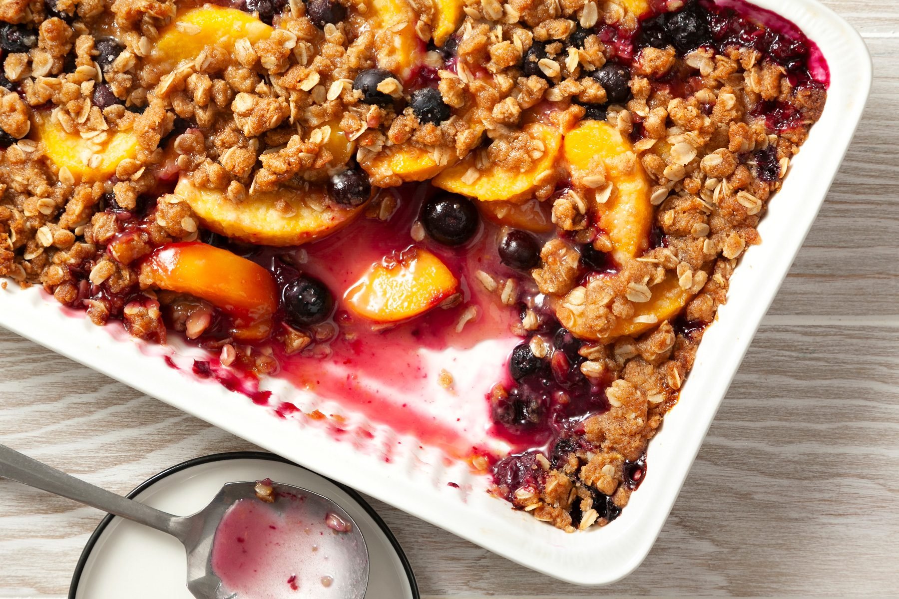 A tray of Peach Blueberry Crisp on a wooden table