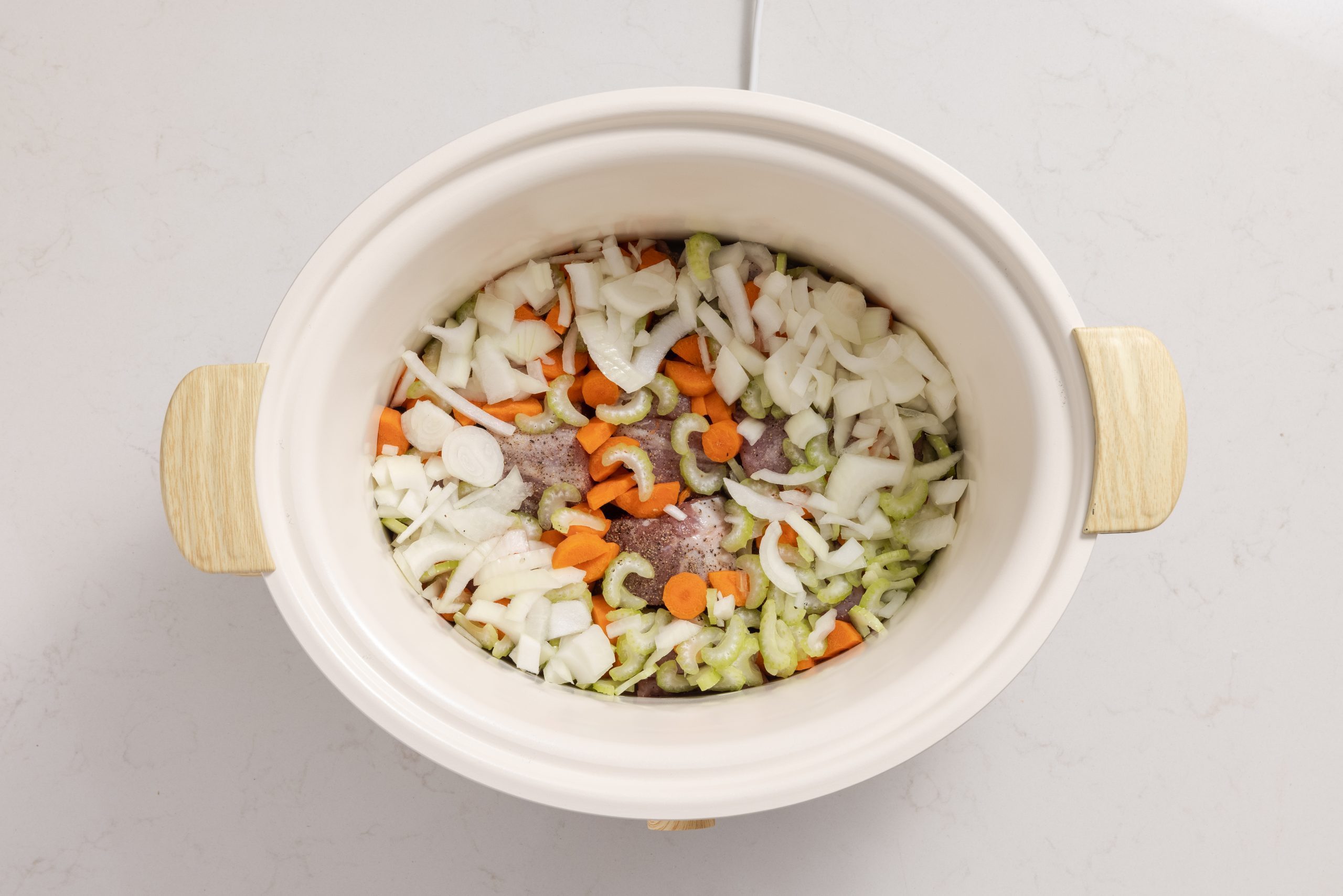 Ingredients for pork stew inside the slow cooker.