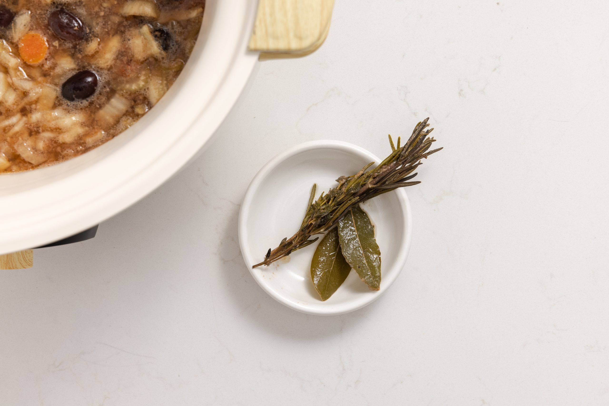 Herbs being removed from slow cooker.