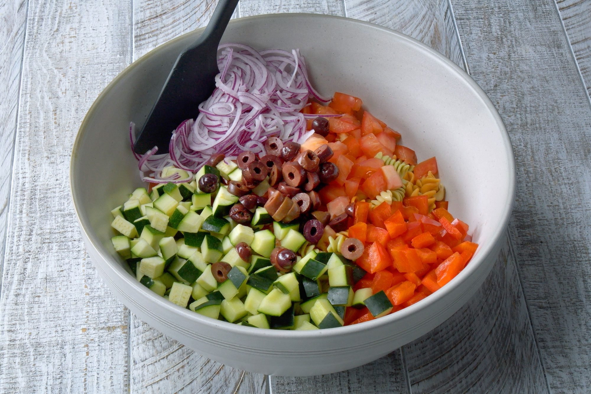 high angle shot of chopped vegetables in a large bowl; wooden background;