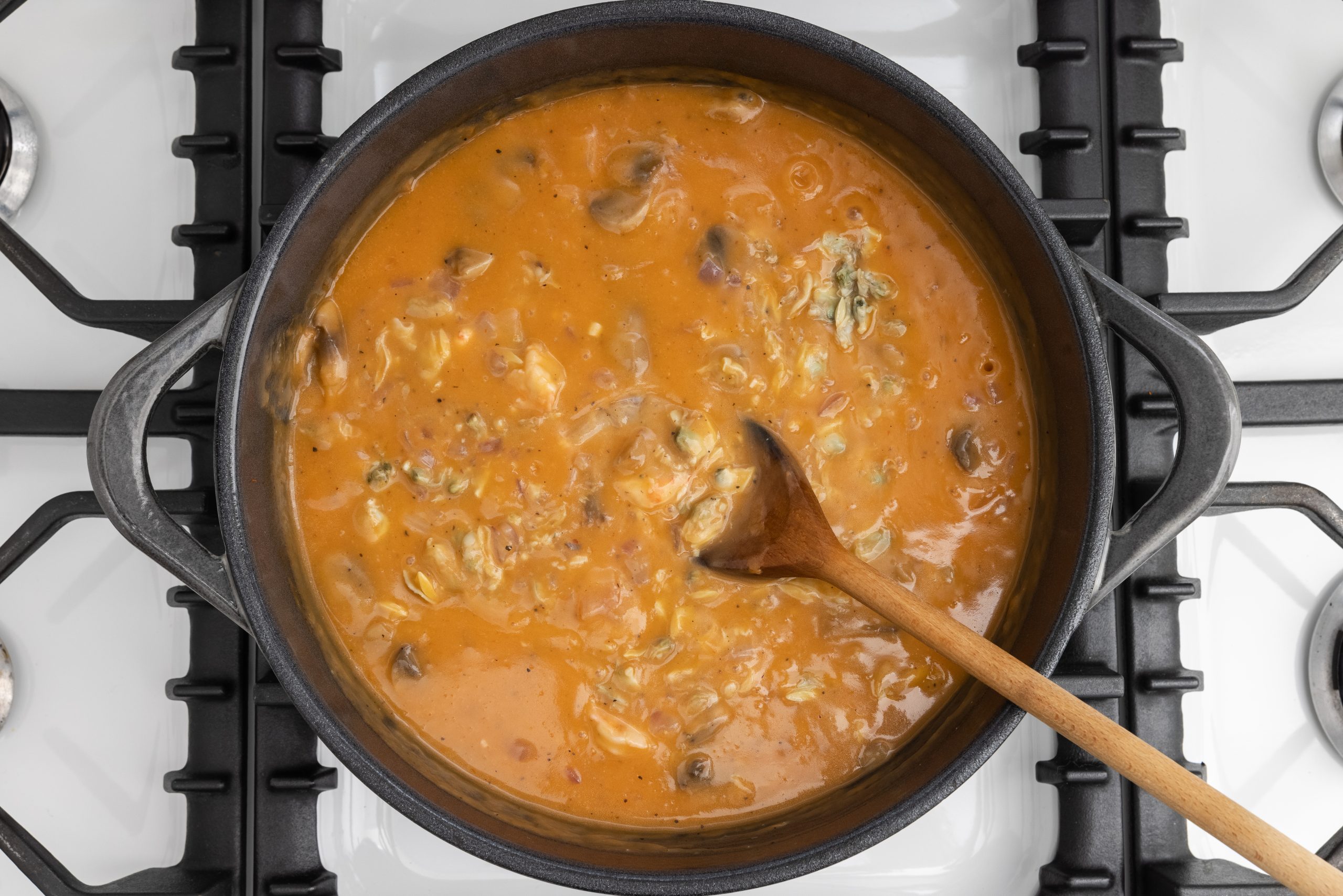 Dutch oven with seafood added to the bisque mixture.