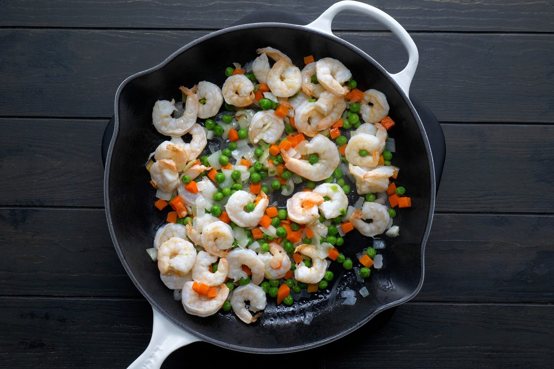 In a large skillet or wok, saute the shrimp, onion, peas, and carrots in oil